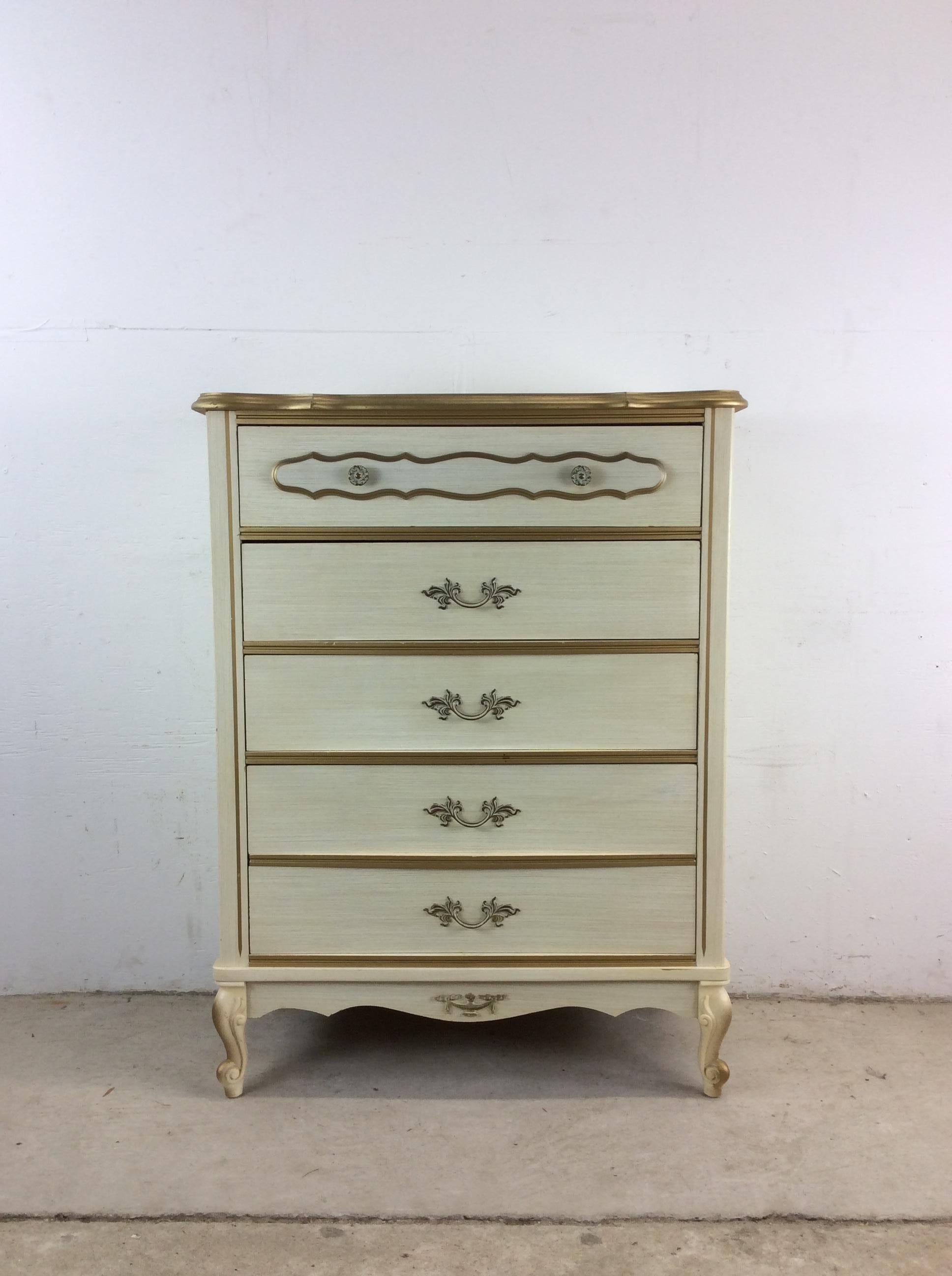 This mid century French provincial style Highboy dresser features pressed wood construction, four dovetailed drawers, white lacquer finish, unique ornate hardware, and tapered legs.   Matching lowboy dresser with mirror, pair of end tables, and