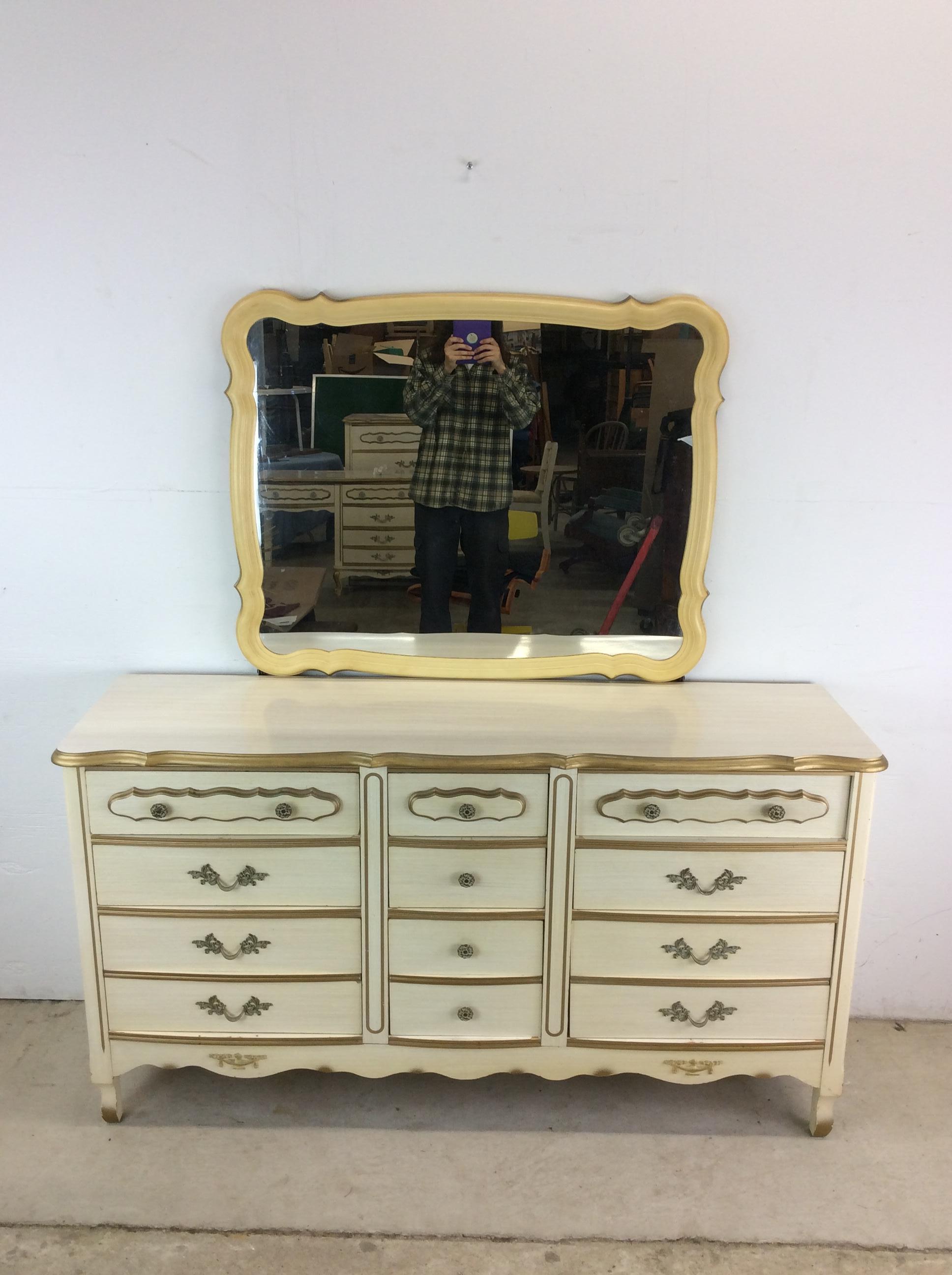 This mid century French provincial style lowboy dresser features pressed wood construction, white lacquer finish, nine dovetailed drawers with ornate hardware, and mounted mirror with molded plastic frame.   Matching Highboy, pair of nightstands and
