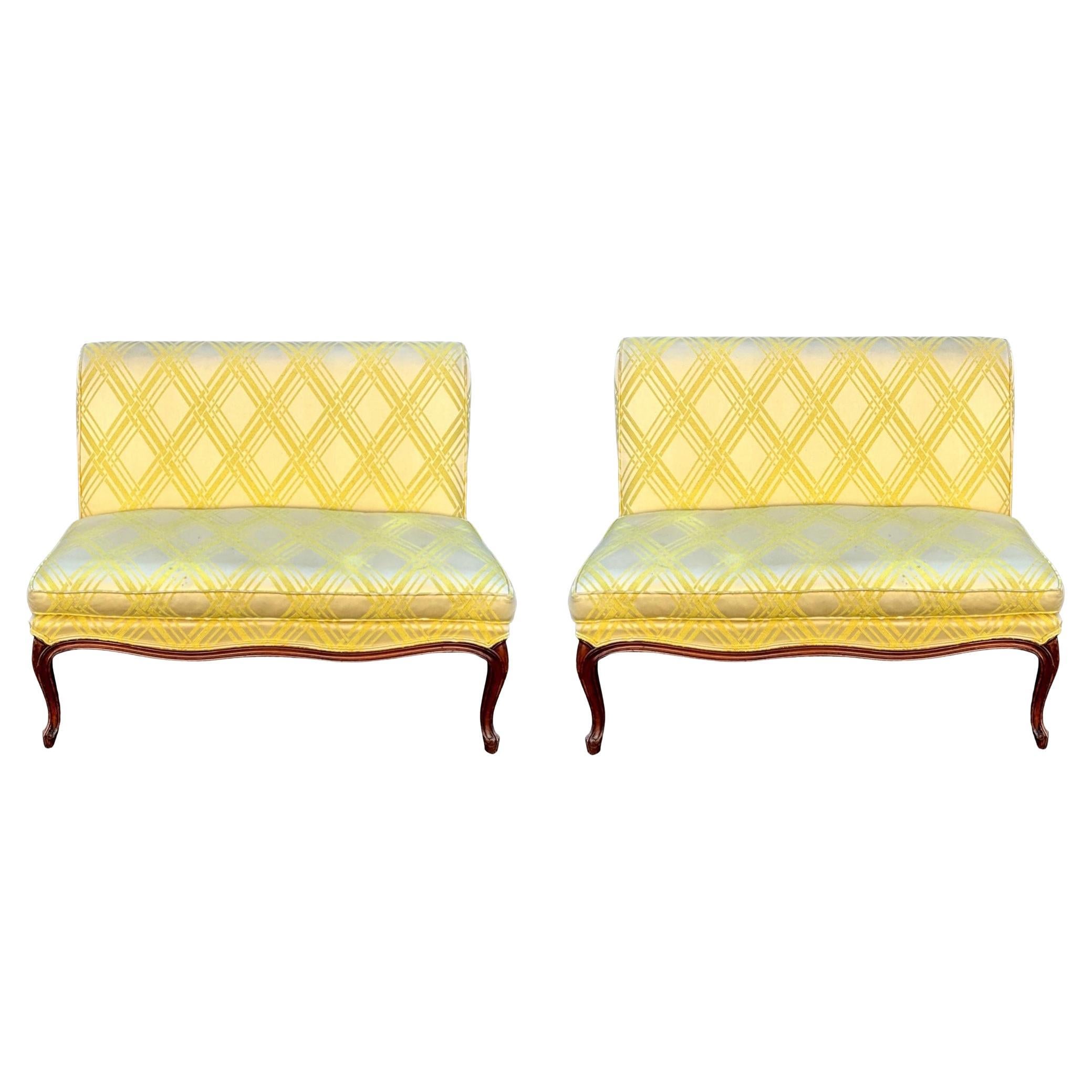This is a lovely pair of midcentury French Provincial style carved fruitwood settees in a pretty vintage yellow fabric. They are American and in very good condition. The fabric show slight wear. The yellow feels like a silk blend. They are unmarked.