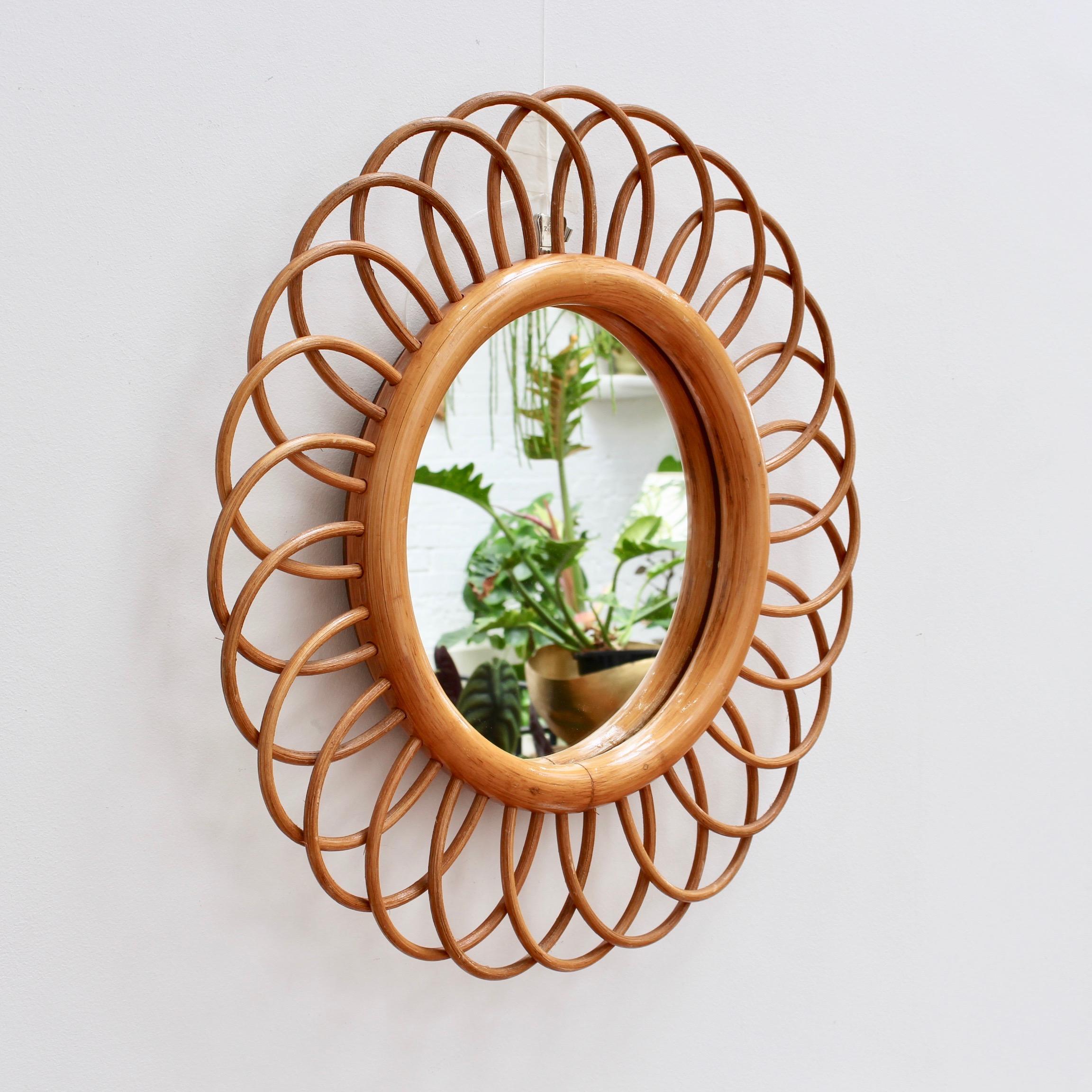 Midcentury French rattan flower-shaped wall mirror, circa 1960s. Charming, uplifting, stylish and very collectible, this mirror is in excellent condition. Upon request a video of this piece will be provided. 

Dimensions:
Dia with frame: 50 cm /