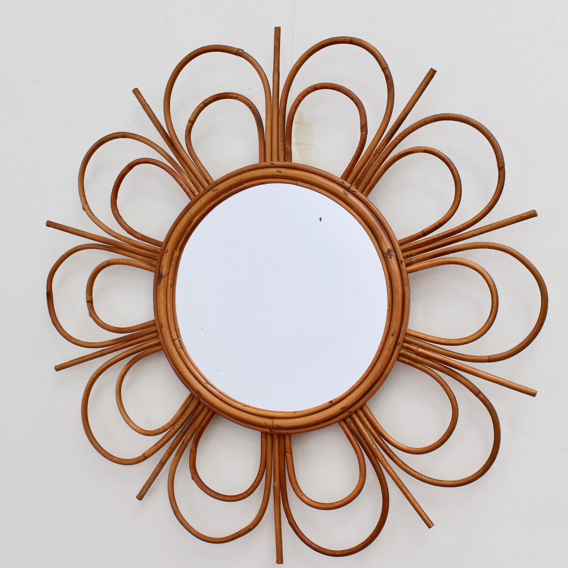 Midcentury French rattan flower-shaped wall mirror, circa 1960s. Very unique, charming, uplifting, stylish and collectible, this mirror is in overall good vintage condition commensurate with its age and usage. There are some evident blemishes on the