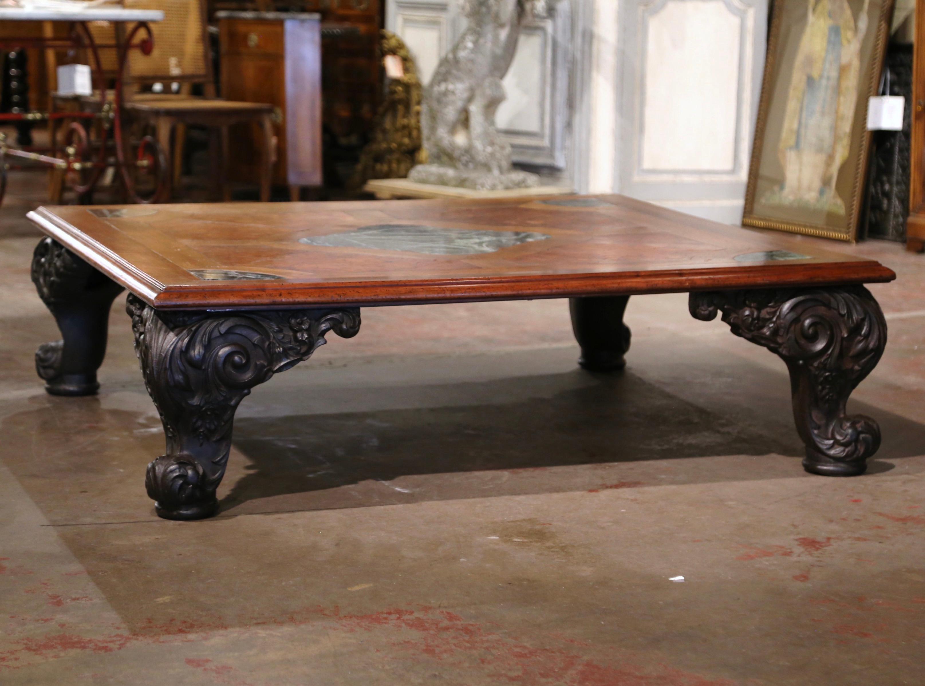 Decorate a formal living room with this important antique cocktail table. Crafted in France circa 1950, and almost five feet square, the elegant table stands on cast iron cabriole legs ending with escargot feet and decorated with acanthus leaves at