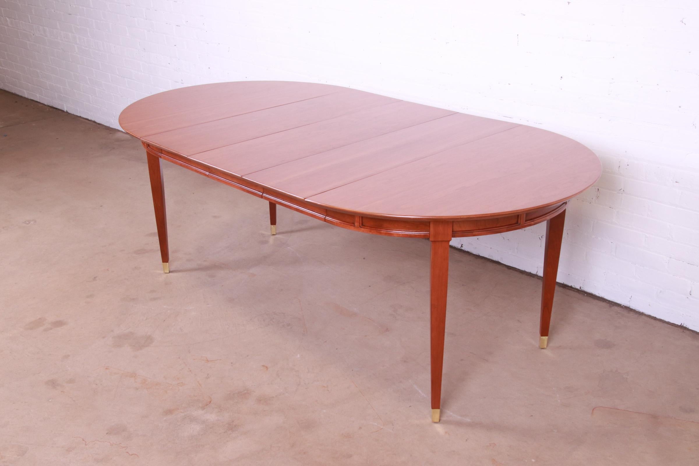 A beautiful mid-century modern French Regency style extension dining table

Recently procured from Frank Lloyd Wright's DeRhodes House

Attributed to Tomlinson

USA, Circa 1950s

Carved cherry wood, with brass-capped feet.

Measures: 44