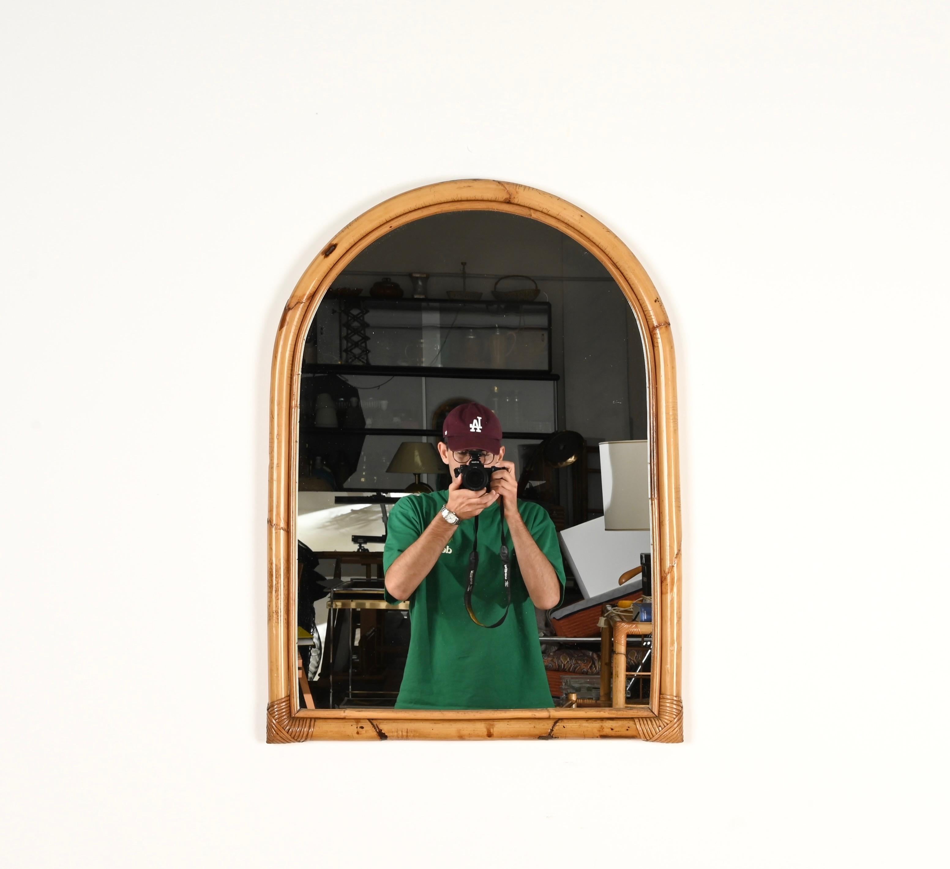Merveilleux miroir arqué du milieu du siècle en bambou courbé et rotin tressé à la main. Ce charmant miroir organique de style Côte d'Azur a été produit en Italie dans les années 1970.

En fabuleux état et d'une charmante couleur miel, entièrement