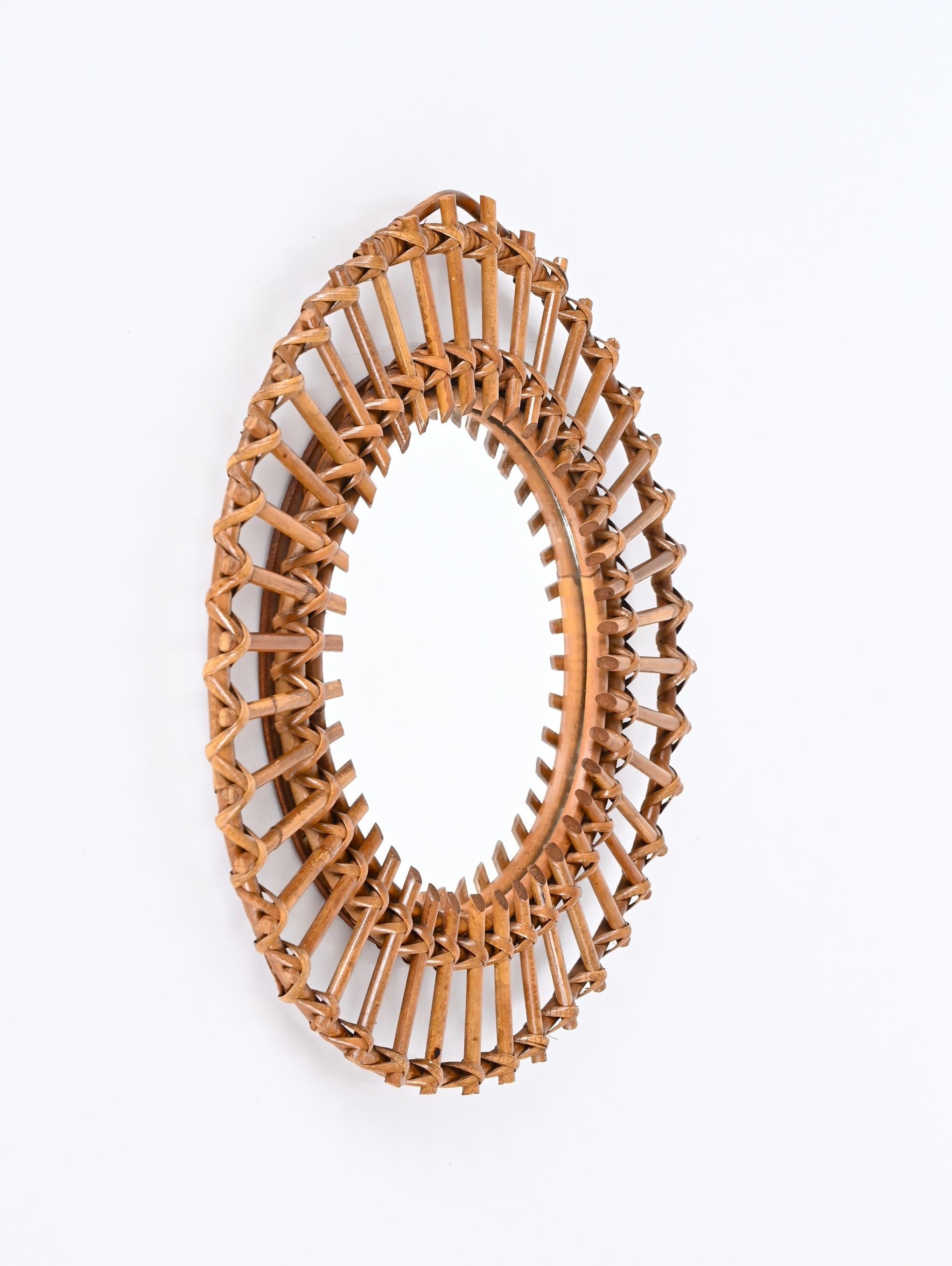 Gorgeous mid-century French Riviera rattan and bamboo Italian round mirror, this beautiful mirror was produced in Italy during the 1960s.


This stunning mirror consists of two round frames in curved rattan decorated by straight rattan beams that