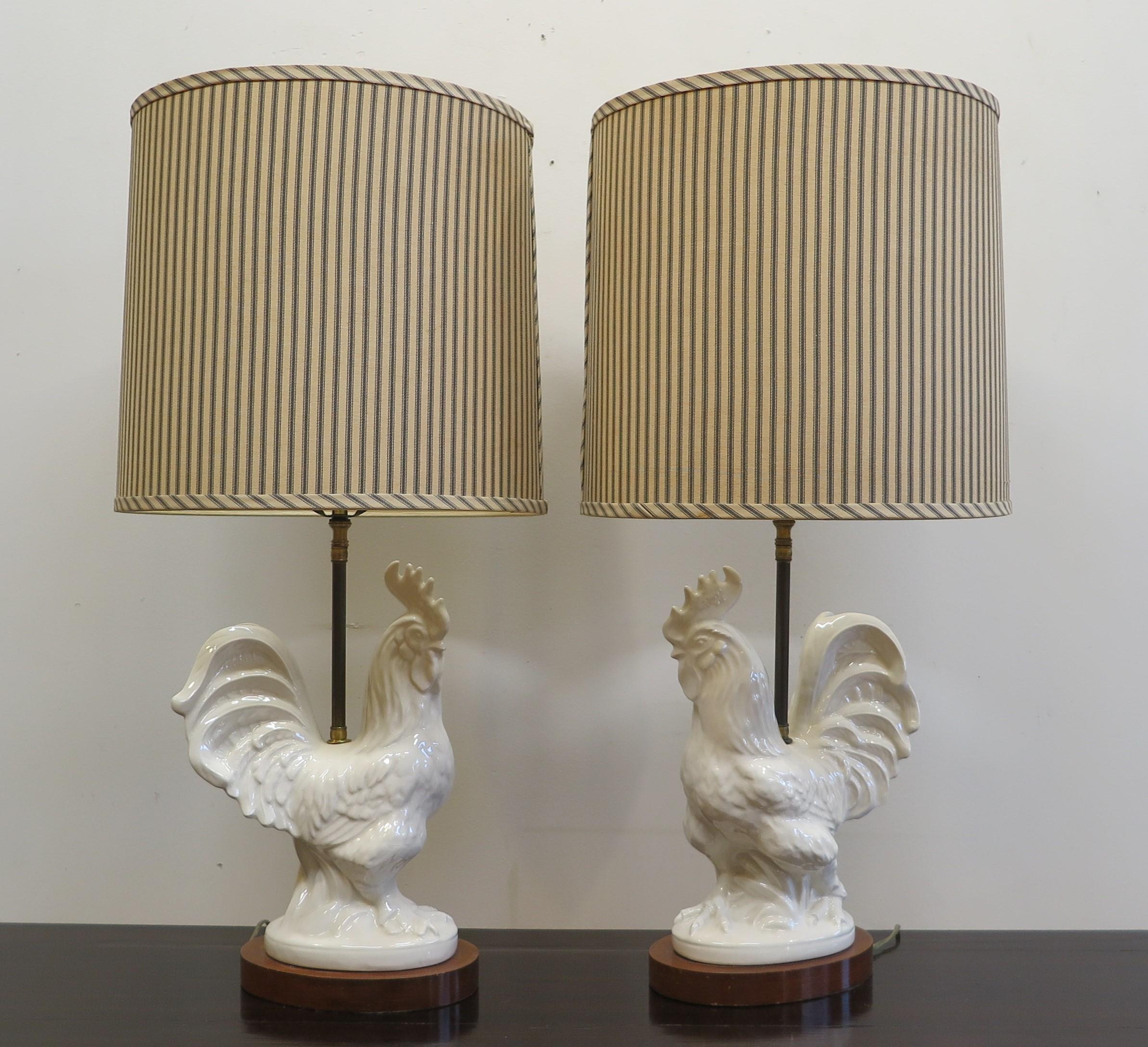 French Mid Century rooster table lamps. White ceramic rooster statues on solid wood stands with Fabric Shades. The shades are 14 inch diameter. Very well done ceramic with true to life details made of fine quality. Having a crackle glaze that over