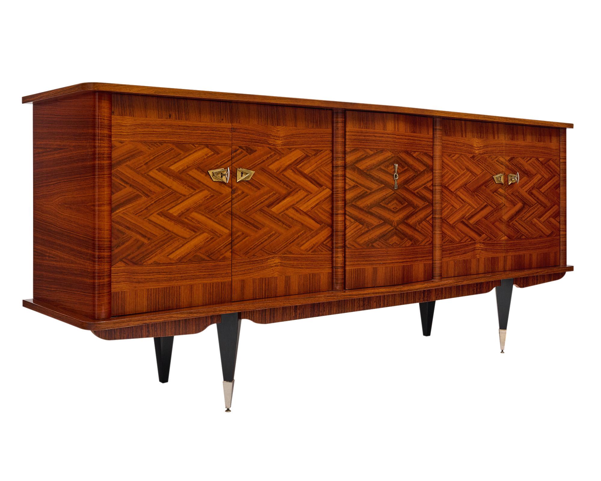 Buffet from France in the mid-century style. The enfilade features an eye-catching rosewood veneer in a woven pattern. There are two sets of doors that open to reveal a lemon wood interior with shelving and dovetailed drawers. The center panel opens
