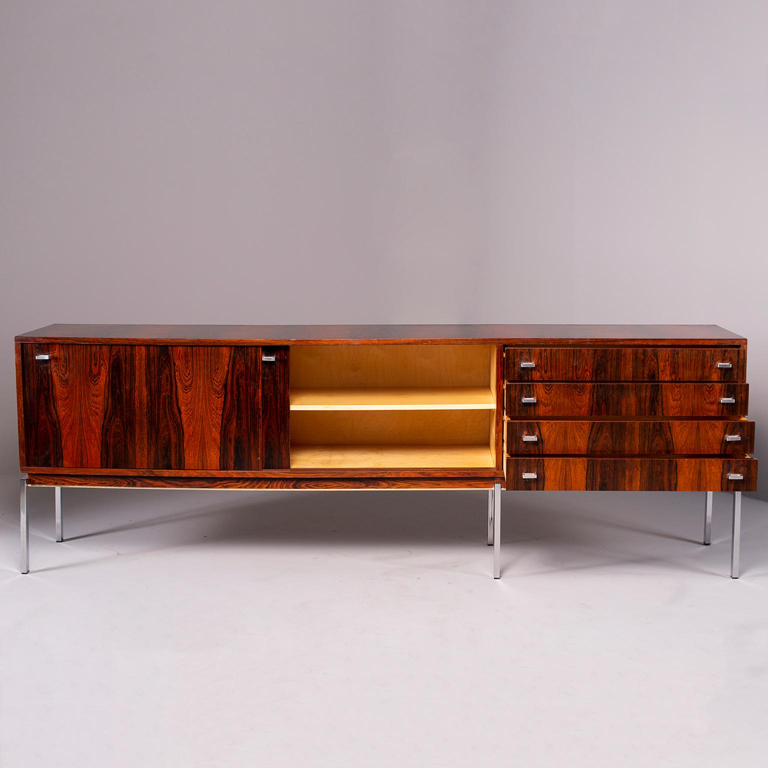 Dramatically grained French rosewood credenza or cabinet dates from the 1960s. Long and low, this versatile piece can be used in an office, dining room, or living room. Four functional drawers and two storage compartments with sliding doors. Silver