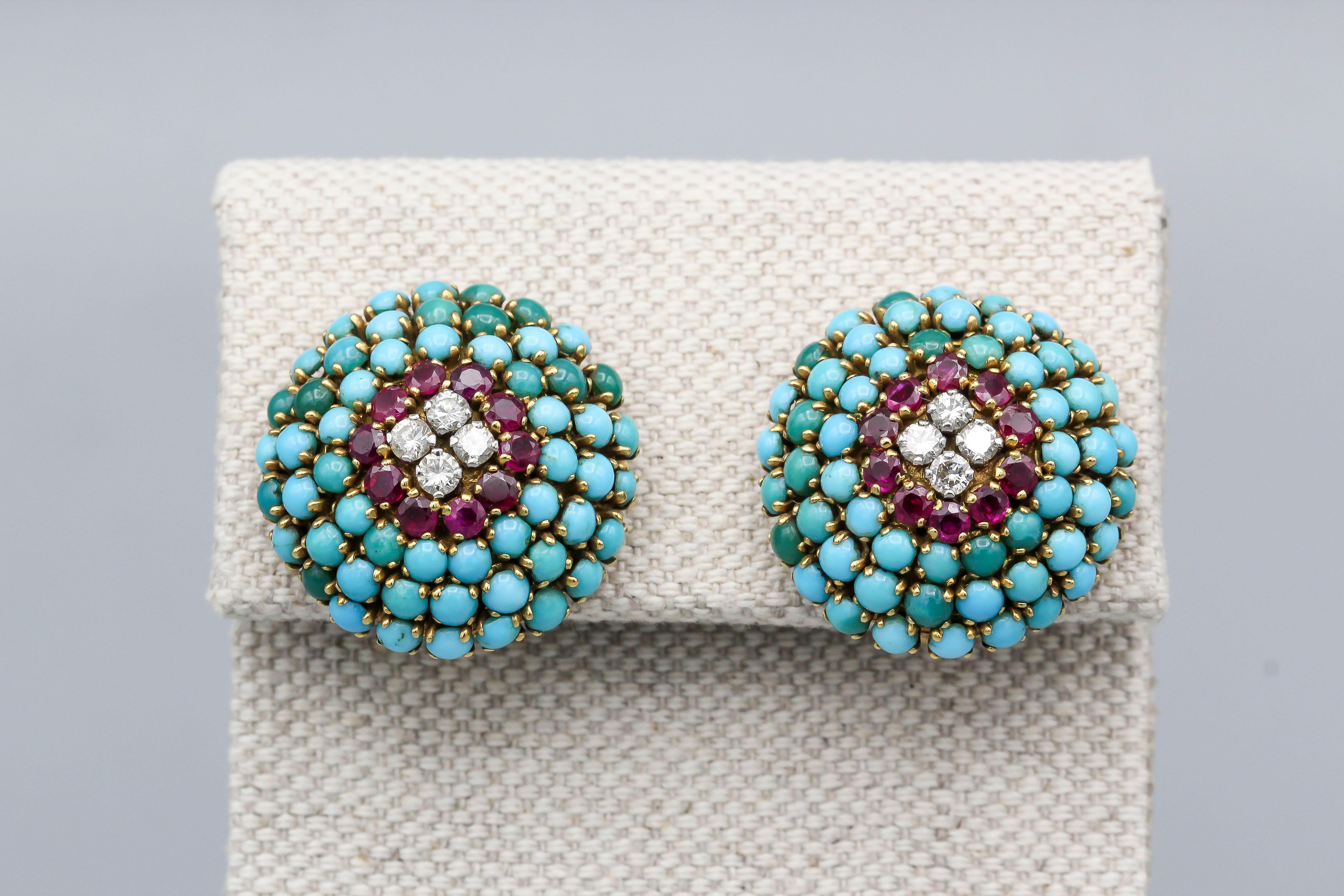 Fine pair of 18k gold earrings of French origin, circa 1950s.  They feature tree rows of Persian turquoise cabochons circling around one row of rich red faceted rubies, and centered with white brilliant cut diamonds.  

Hallmarks: French 18k gold