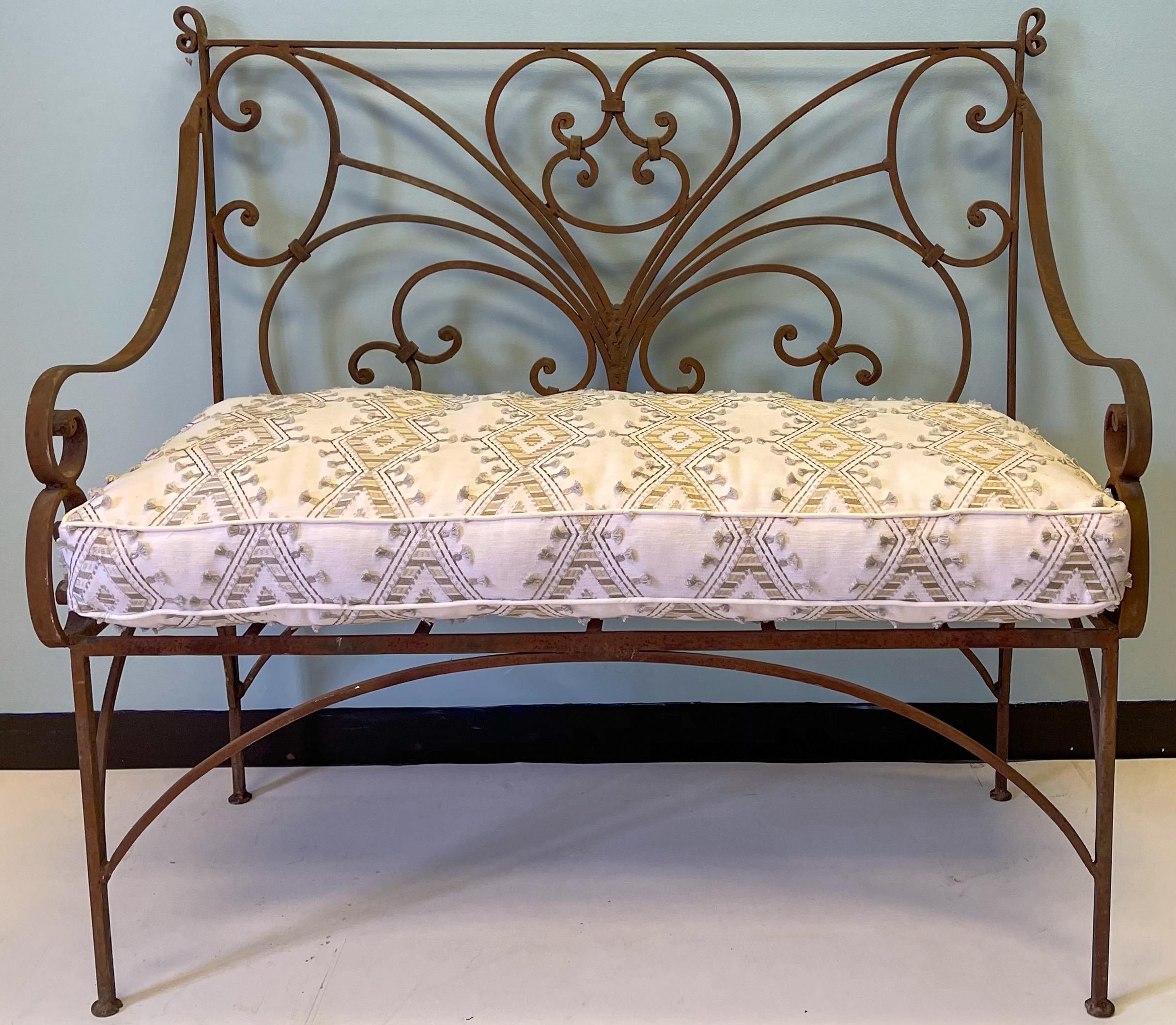This is a wonderful mid-century French scrolling iron garden settee or bench. The white cushion is new. The metal does show some age wear.