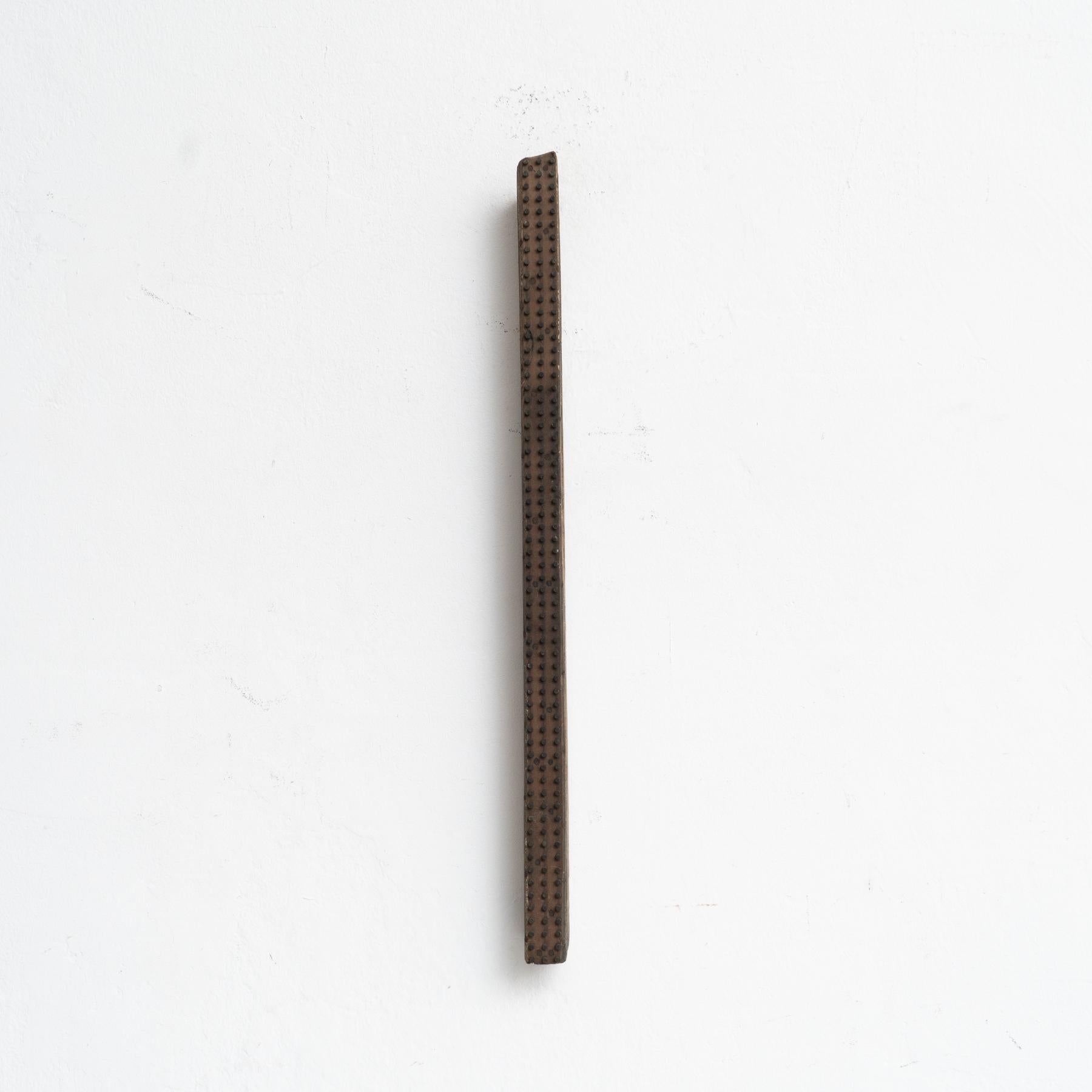 Elegant mid-century sculptural artwork crafted in France, circa 1950, by an unknown artist. This striking piece showcases a harmonious blend of wood and repeated metal inlays, creating a unique and visually captivating design.

Preserved in its