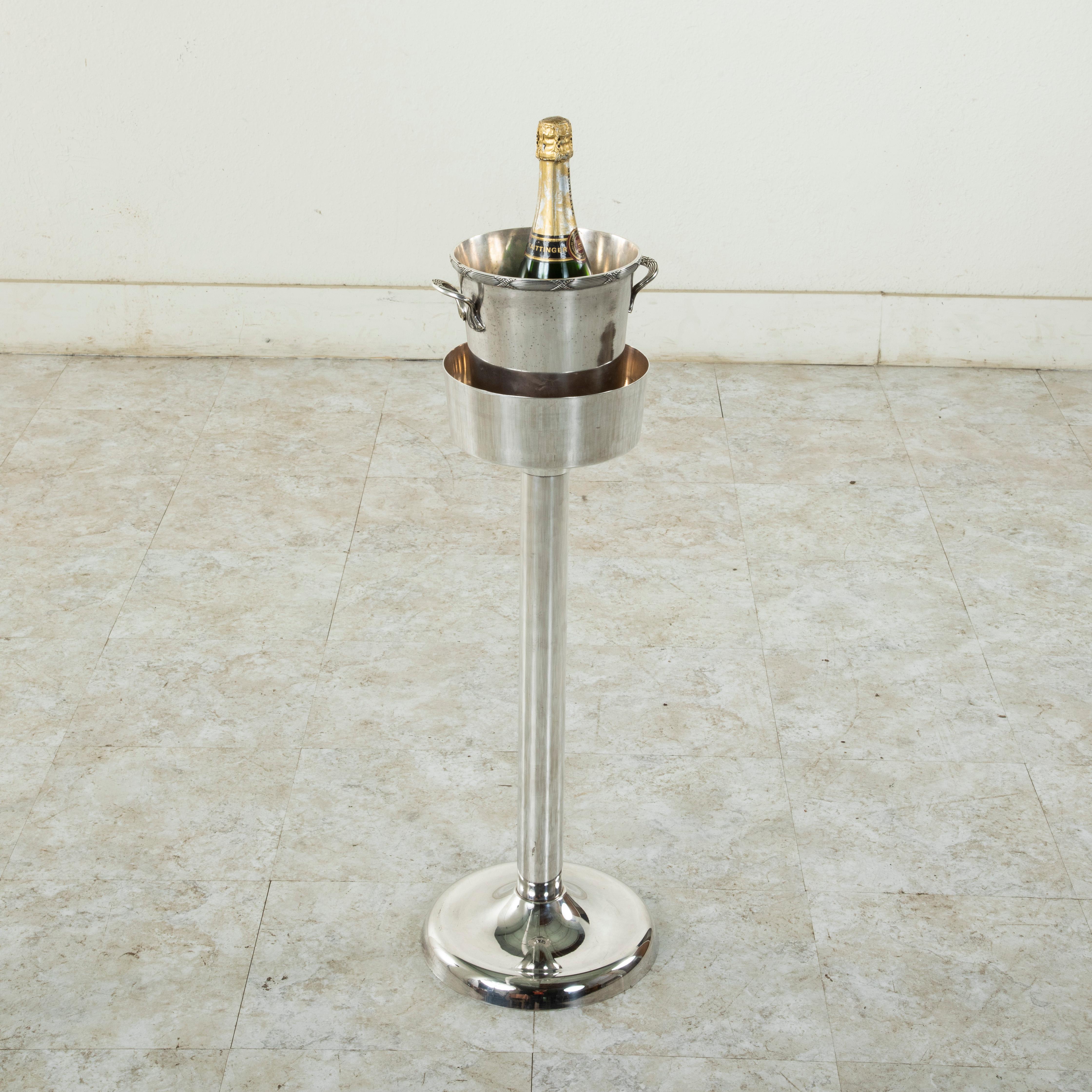 Originally used in a French restaurant to be placed beside a dining table, this silver plate champagne stand contains its original insert used to keep a champagne bucket upright and level. The stand is 26.25 inches in height with an 8 inch diameter