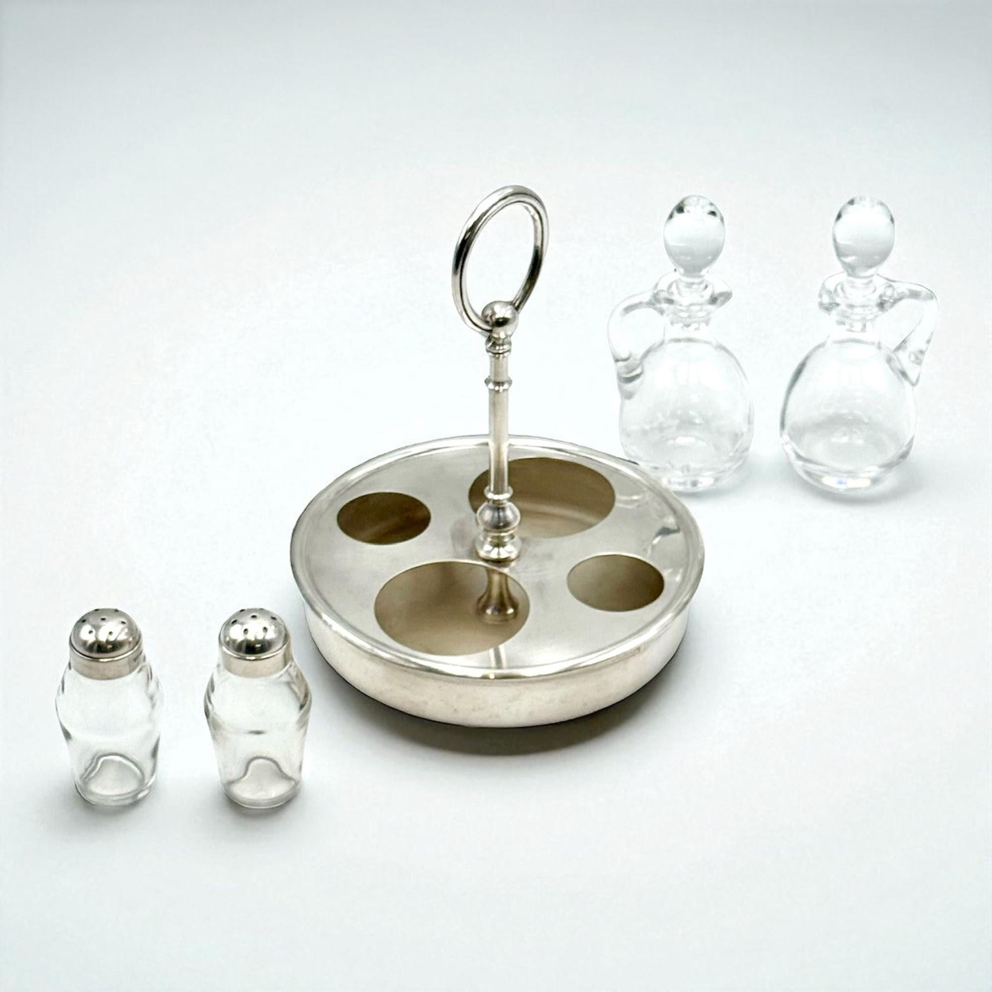 Un service à condiments français sophistiqué du milieu du siècle, fabriqué par la prestigieuse maison Christofle dans les années 1950. Issu de la collection Fleuron, cet accessoire de table raffiné présente un cadre argenté accueillant quatre