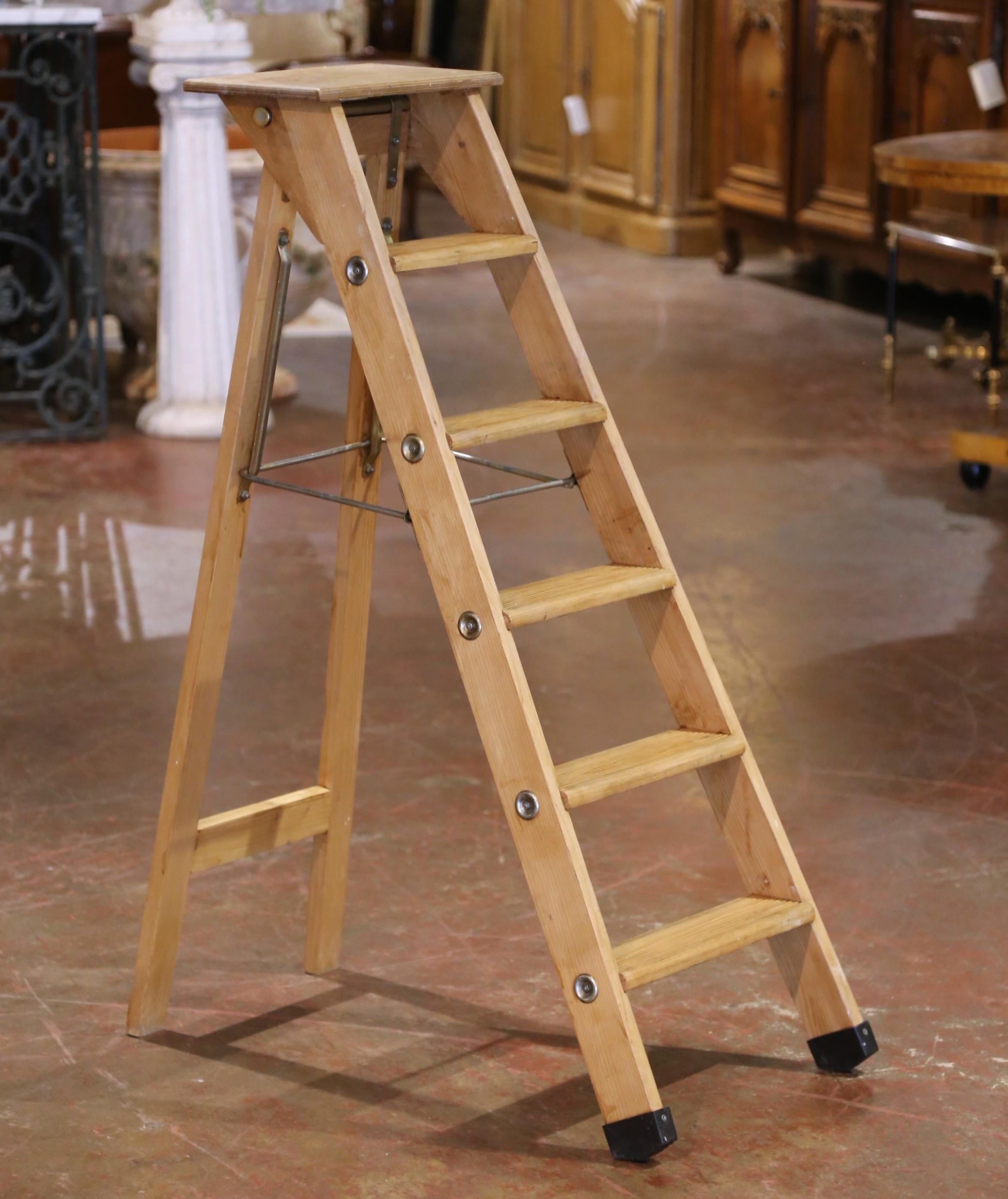 Fabriquée en France vers 1960, cette échelle pliante ancienne à six marches allie le charme rustique à la fonctionnalité du milieu du siècle dernier. Construit en pin massif, il comporte six marches arrondies et une plate-forme supérieure