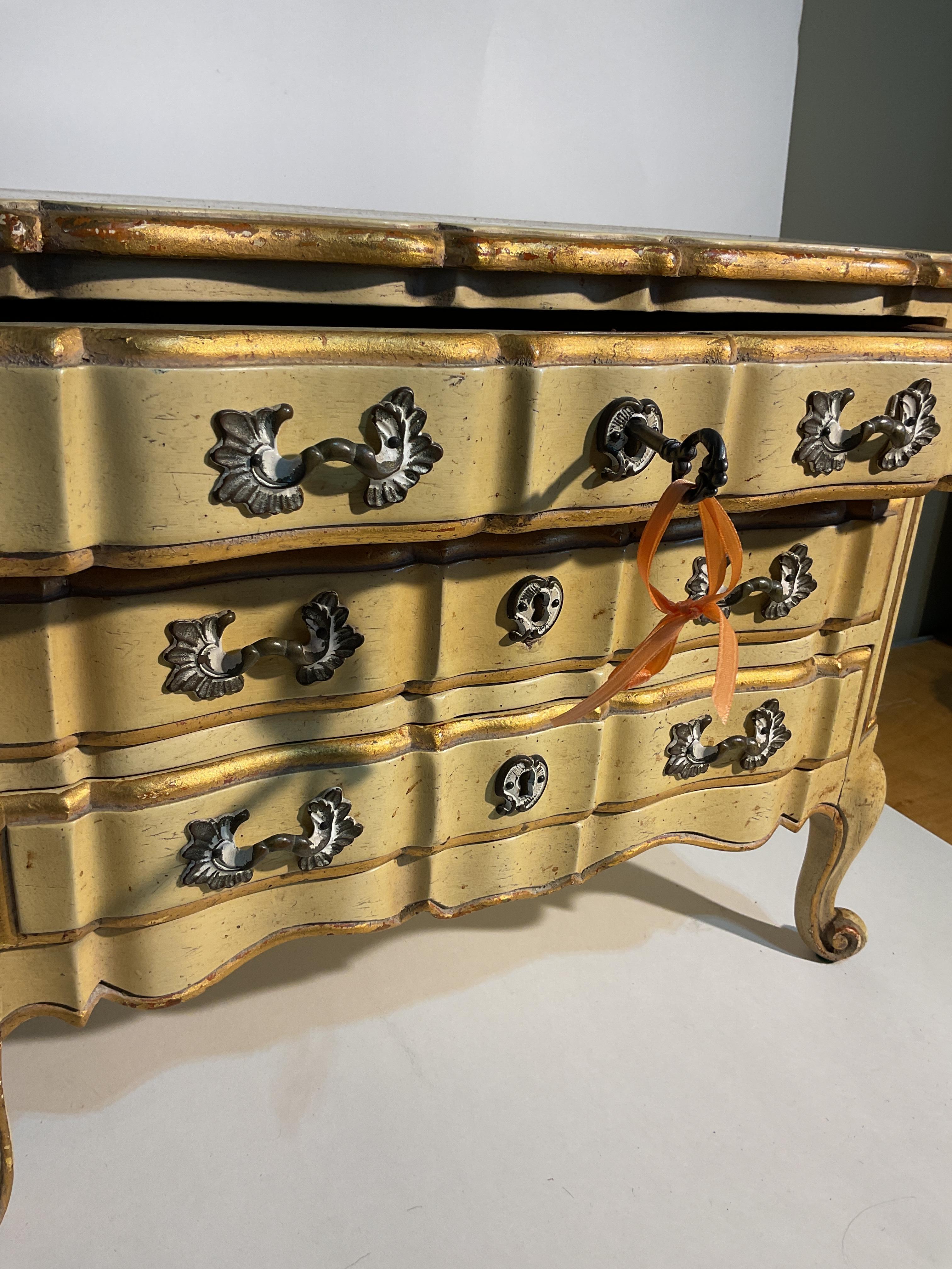 Cómoda en miniatura de mediados de siglo 
Estilo provincial francés
Acentuado con pan de oro y herrajes decorativos
Llave original incluida
Tres cajones con cerradura
Hermosa artesanía
Raro tamaño en miniatura perfecto para guardar joyas
