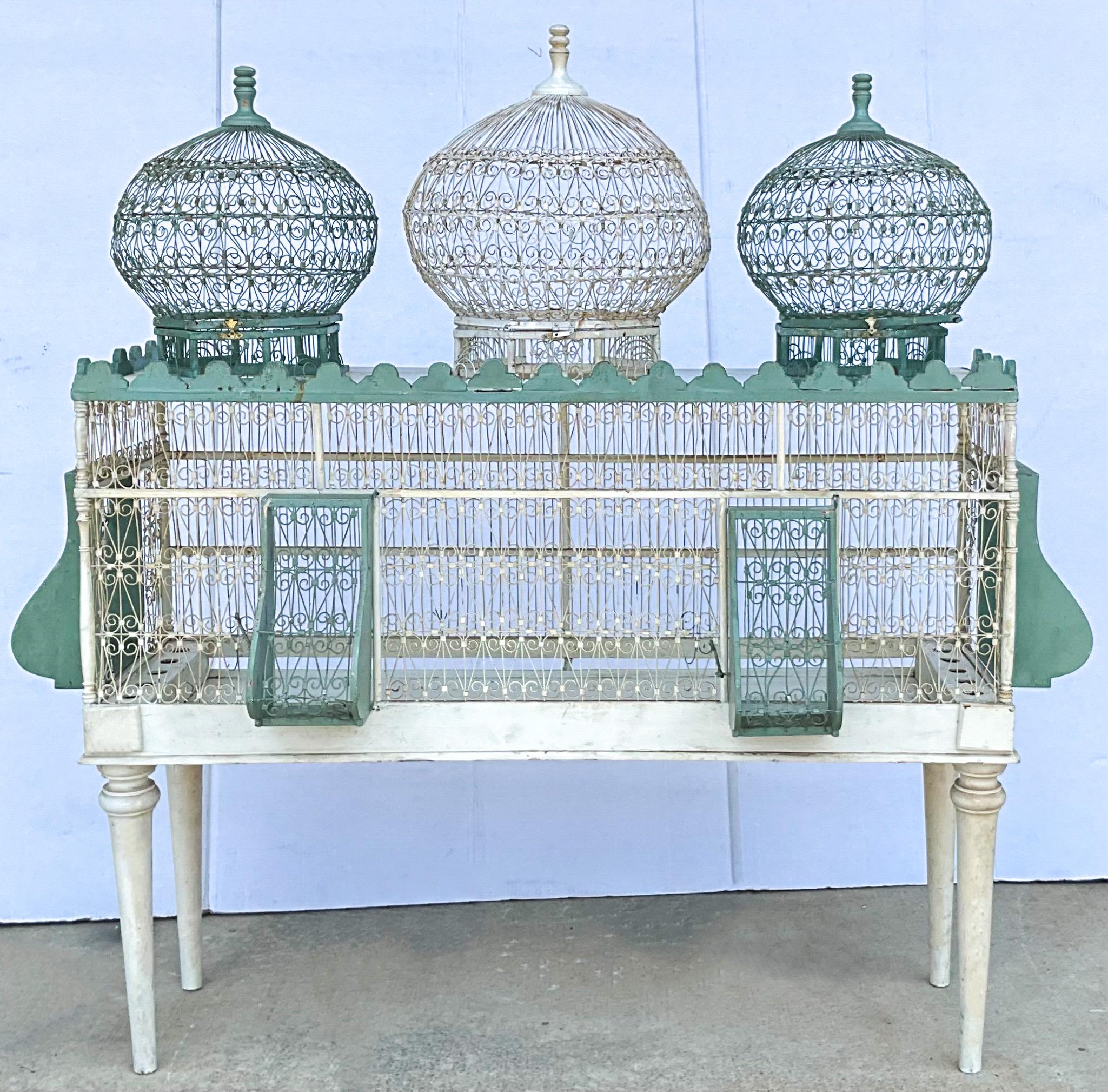This is such an interesting birdcage! I have never had this one. It is actually usable, and I have attempted to clean it. All three of the tops lift off. They have small hinges and hooks. Likewise the additional teal pieces also may be detached from