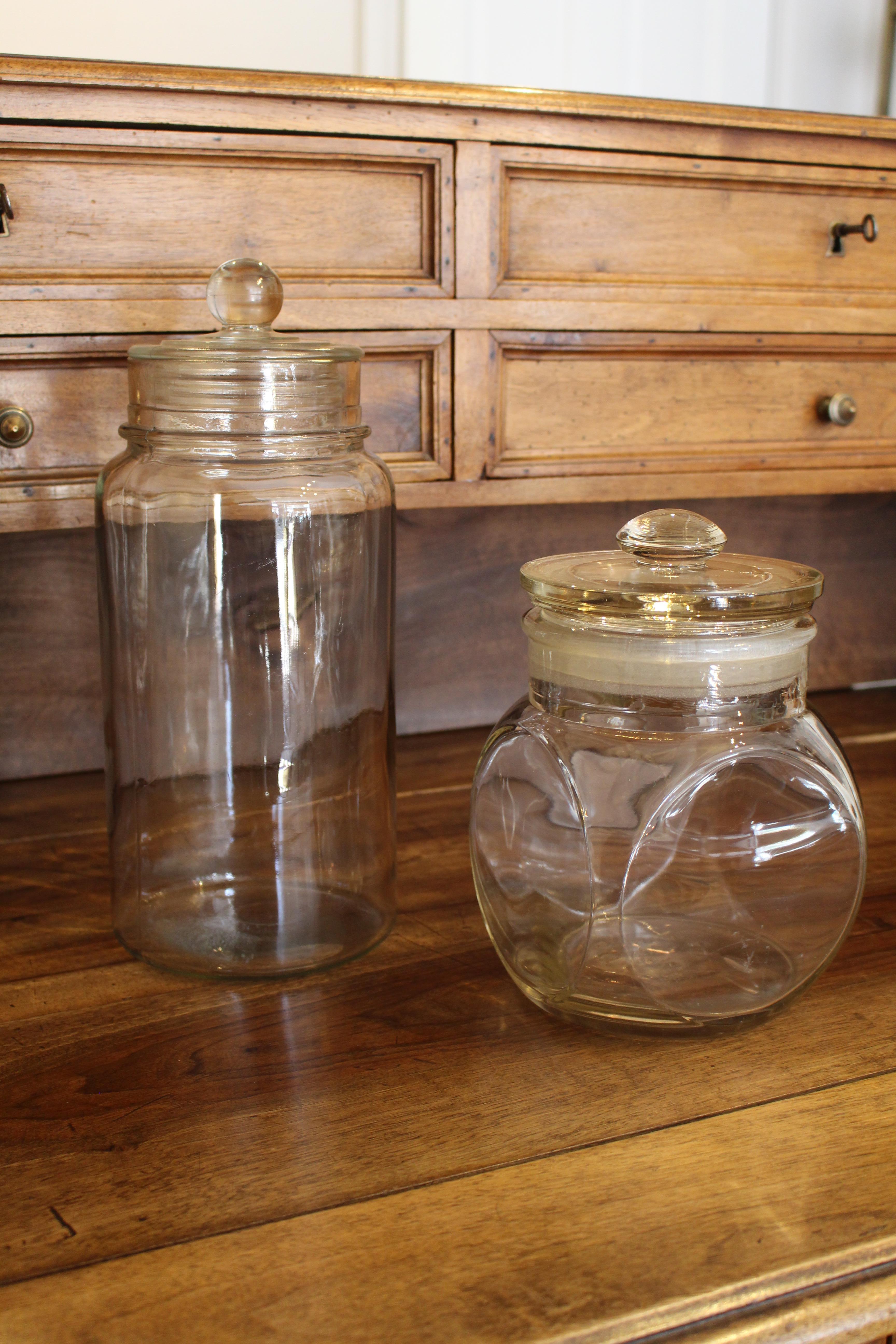 Set of 2 French early to mid-20th century sweet glass jars with lids.
Originally for storage of sweets for sale in shops.

1) The smallest (14 cms wide by 14 cms deep, 21.5 cms tall) is made of pressed glass and is marked on the bottom: S.I.S.A