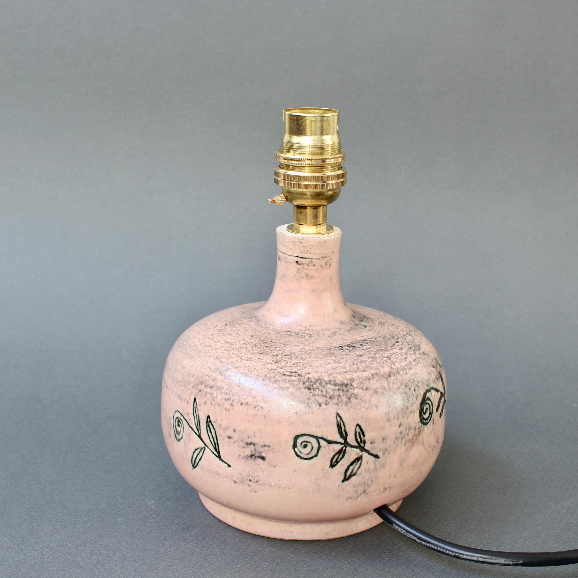 Mid-century ceramic table lamp (circa 1950s) by Jacques Blin. This diminutive pink-hued French lamp (c. 1950s) with sgraffito-etched leaves is in very good overall condition. This size makes this a perfect bedside table lamp with plenty of style.