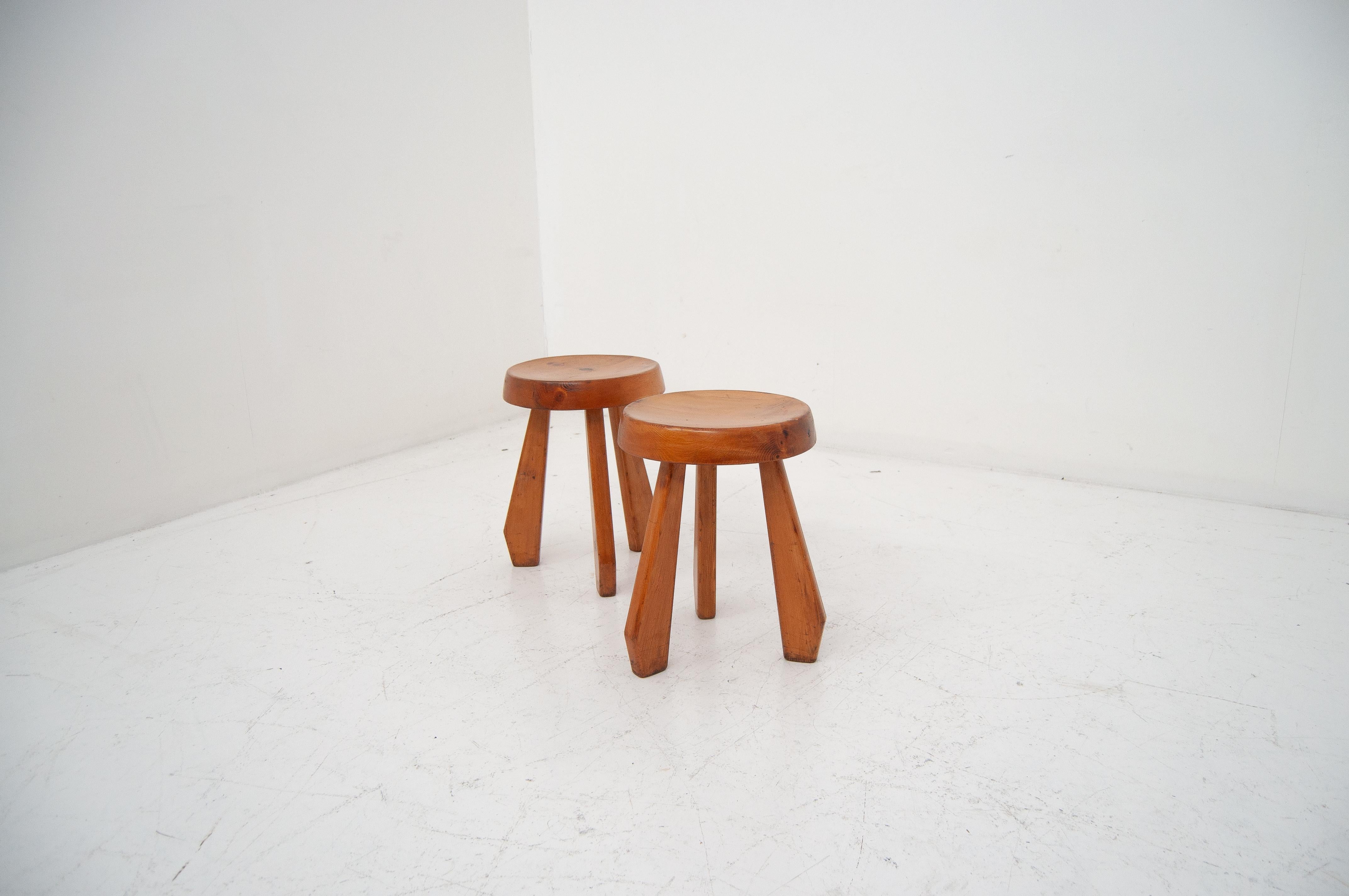 Questo Tabouret Méribel è un pezzo raro e iconico attribuito a Charlotte Perriand, disegnato negli anni '50 per la stazione sciistica di Méribel nelle Alpi francesi. Realizzato in olmo massiccio, riflette l'estetica rustica e moderna di Perriand,