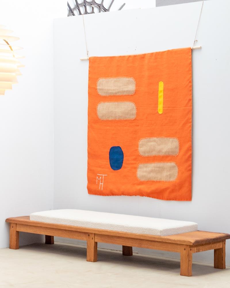 This wall tapestry is crafted in burlap and features a series of overlays, adding depth and texture to the piece. 

Signed 