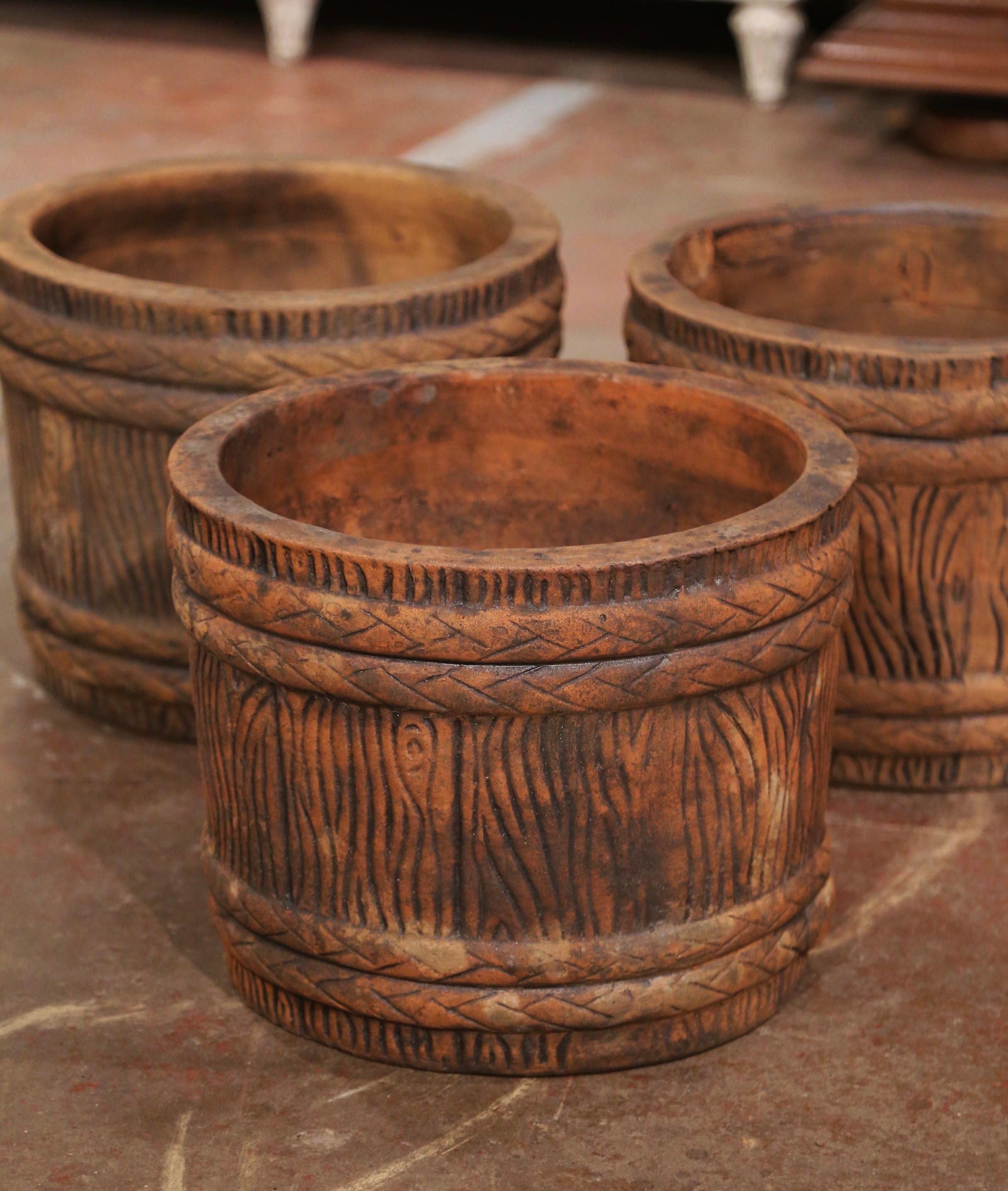 Decorate a patio with this elegant set of antique outdoor planters. Carved in France, circa 1970, each terracotta jardinière with drain hole to center, is round in shape with barrel and tree trunk form. The jardinieres are in excellent condition