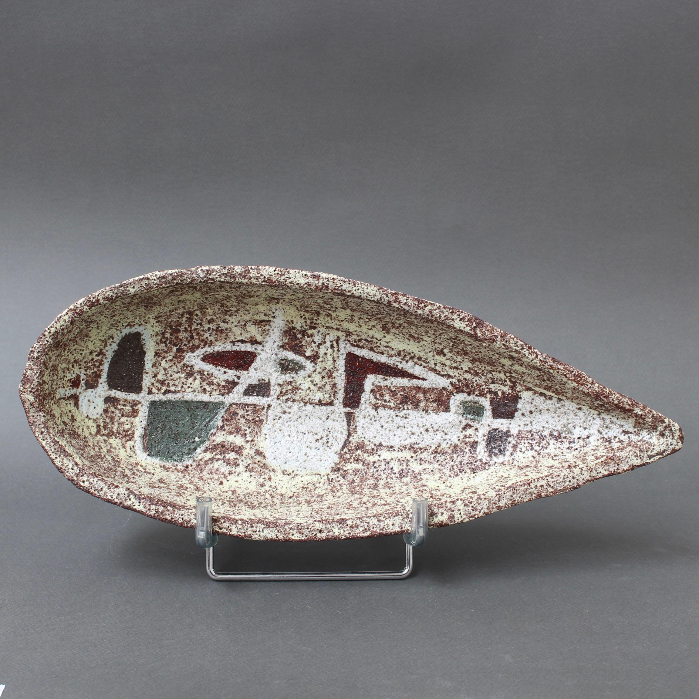 Mid-century textured ceramic dish by Accolay (circa 1960s). An intriguing piece of ceramic sculpture, the dish takes the form of a skiff or, one might suggest a large avocado. The finish however, is of grainy stone, very tactile and weighty. At the