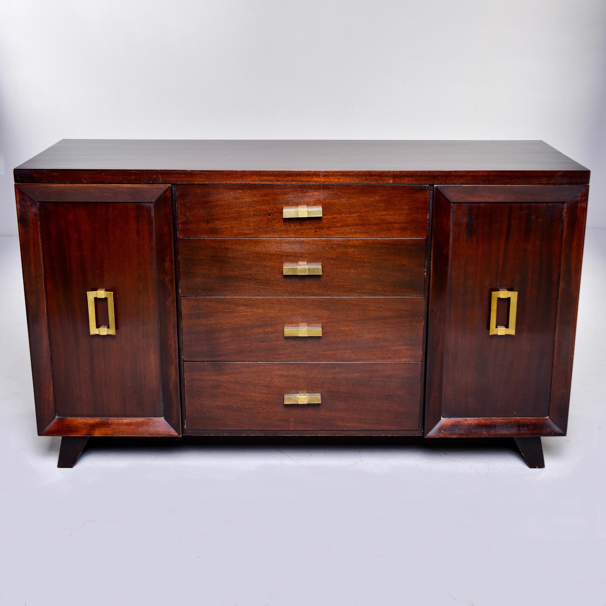 French buffet in dark walnut with four center drawers flanked by two side cabinets, circa 1950s. Each cabinet features a top fabric lined divided drawer over a storage compartment with single interior shelf. Original brass hardware, angled legs and