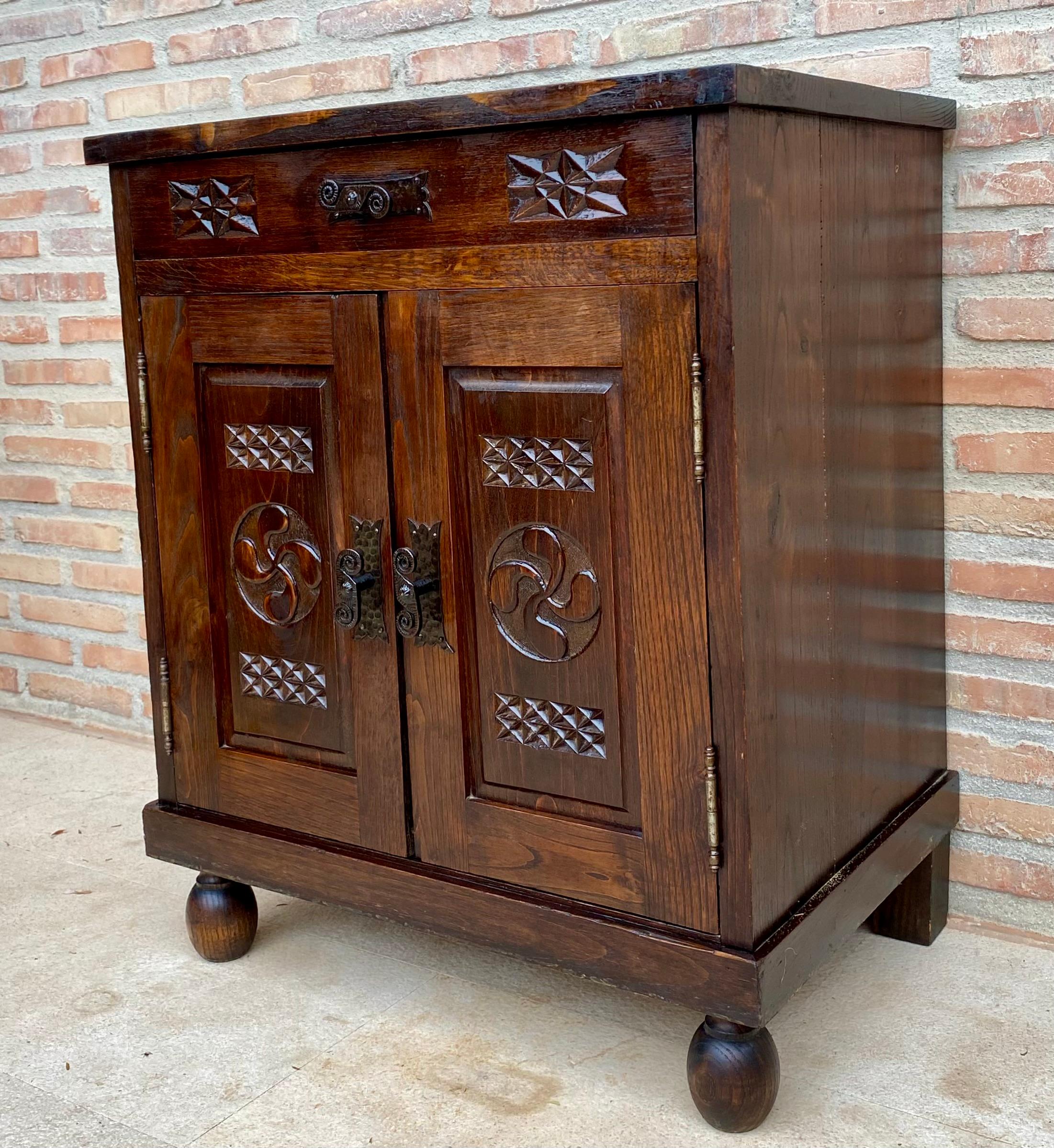Tavolino in noce francese degli anni '50, molto utile per il soggiorno con cassetto intagliato e doppia anta intagliata con maniglie in ferro e un grande ripiano all'interno.