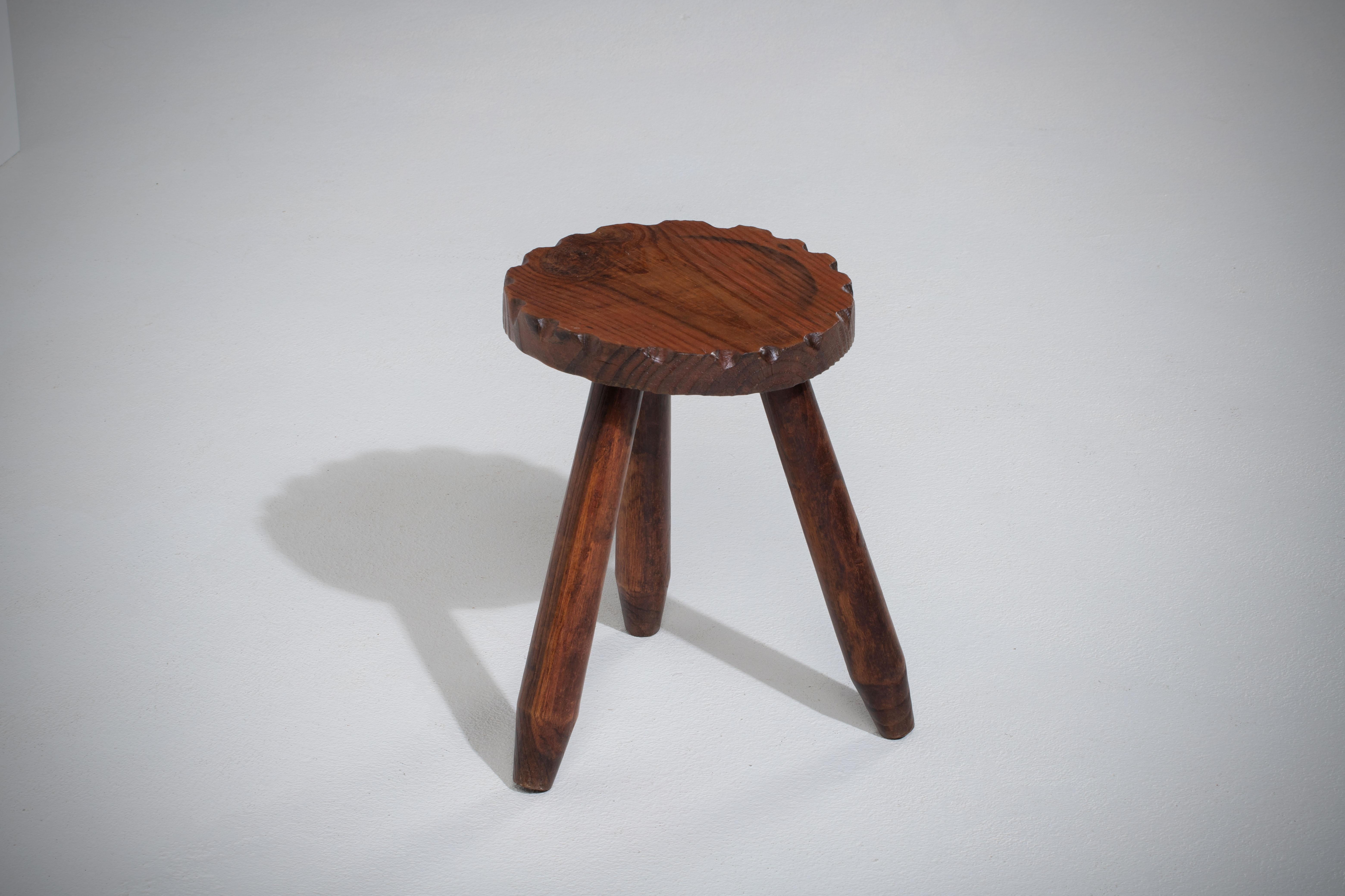 Introducing a fantastic mid-century wooden stool, crafted in France during the 1960s. This piece is constructed without the use of hardware, boasting an elegant octagonal seat, flared legs, and intricate gouge work, all made from rich walnut.

The
