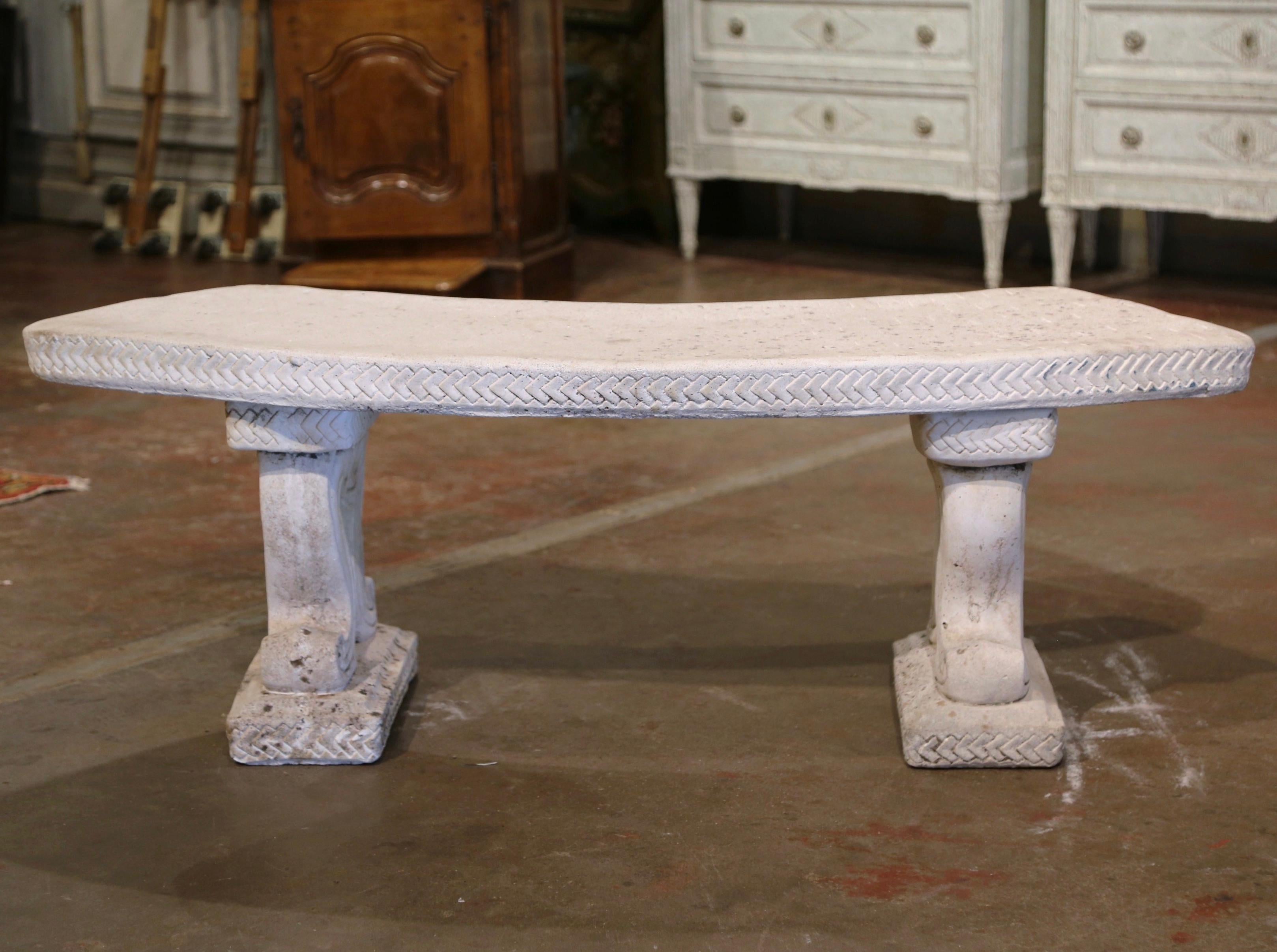 Decorate a garden or a patio with this elegant vintage outdoor bench. Carved in France circa 1960 and built in three separate pieces, the stone bench stands on dual carved scrolled bases over a curved seat decorated with incised trim border. The
