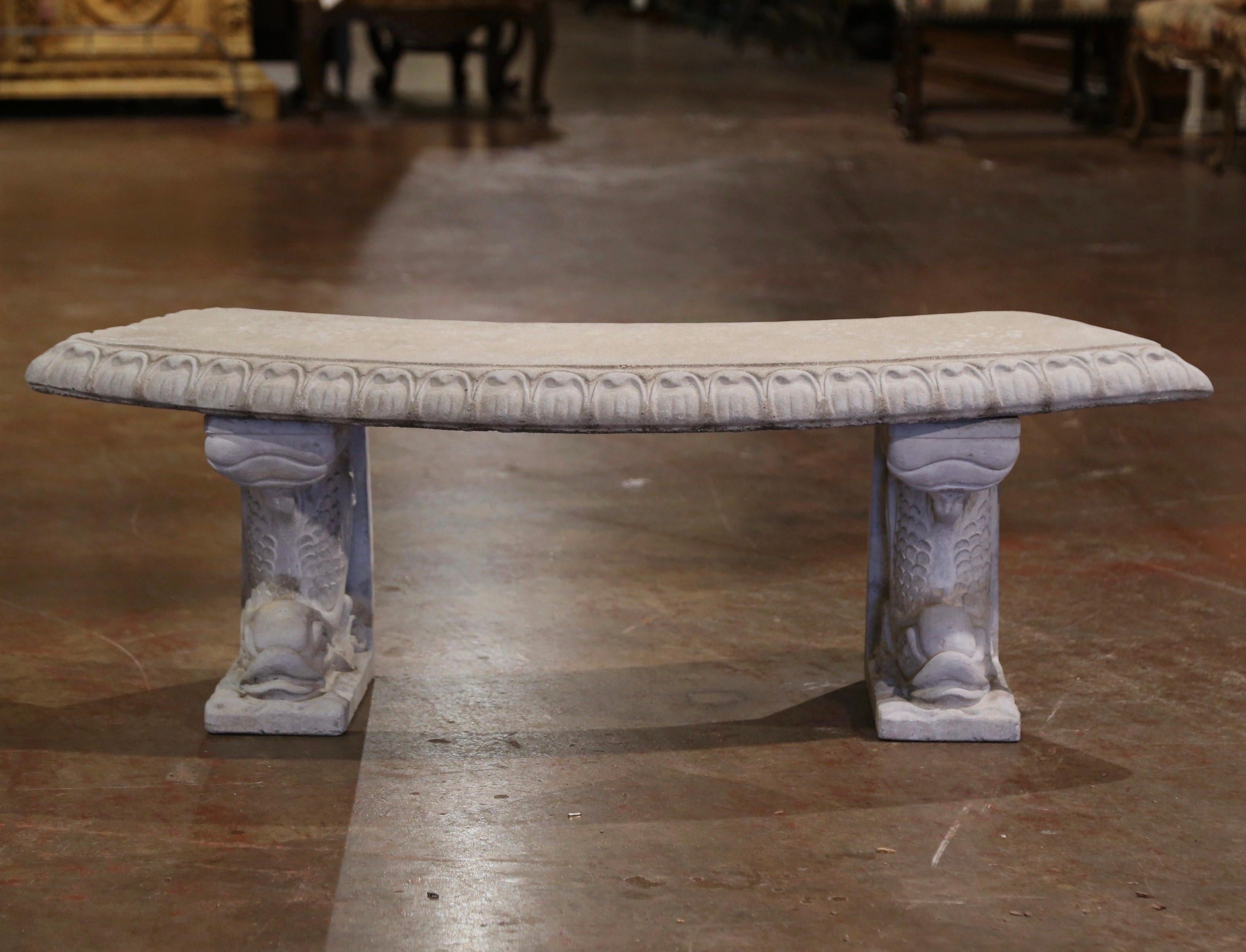 Decorate a garden or a patio with this elegant vintage outdoor bench. Carved in France circa 1960, the stone bench stands on dual carved fish figures bases over a curved seat decorated with egg and dart trim. The seating is in excellent condition