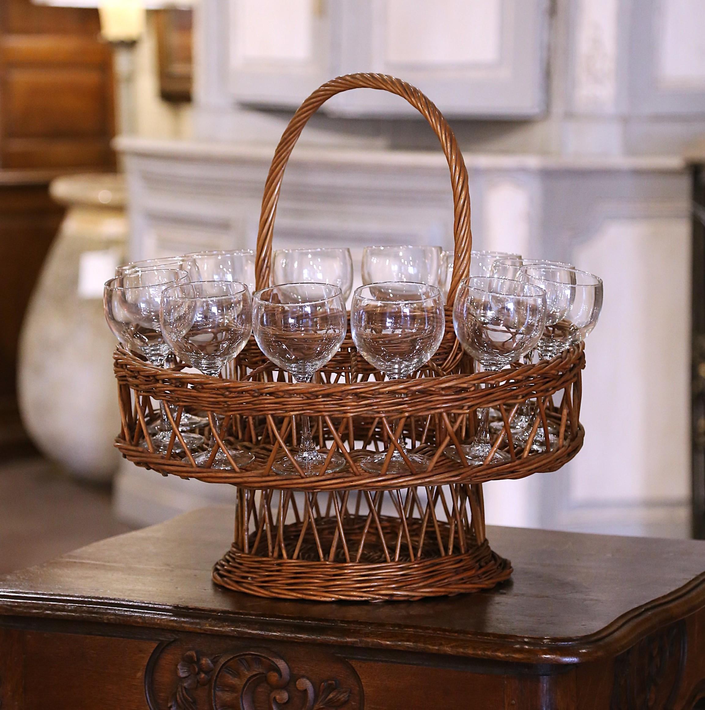 Decorate the top of a cabinet with this vintage wicker basket carrier. Crafted in Normandy or Burgundy circa 1960, the elegant handwoven piece features a gracefully arched central handle and a thoughtful design for both function and charm. The