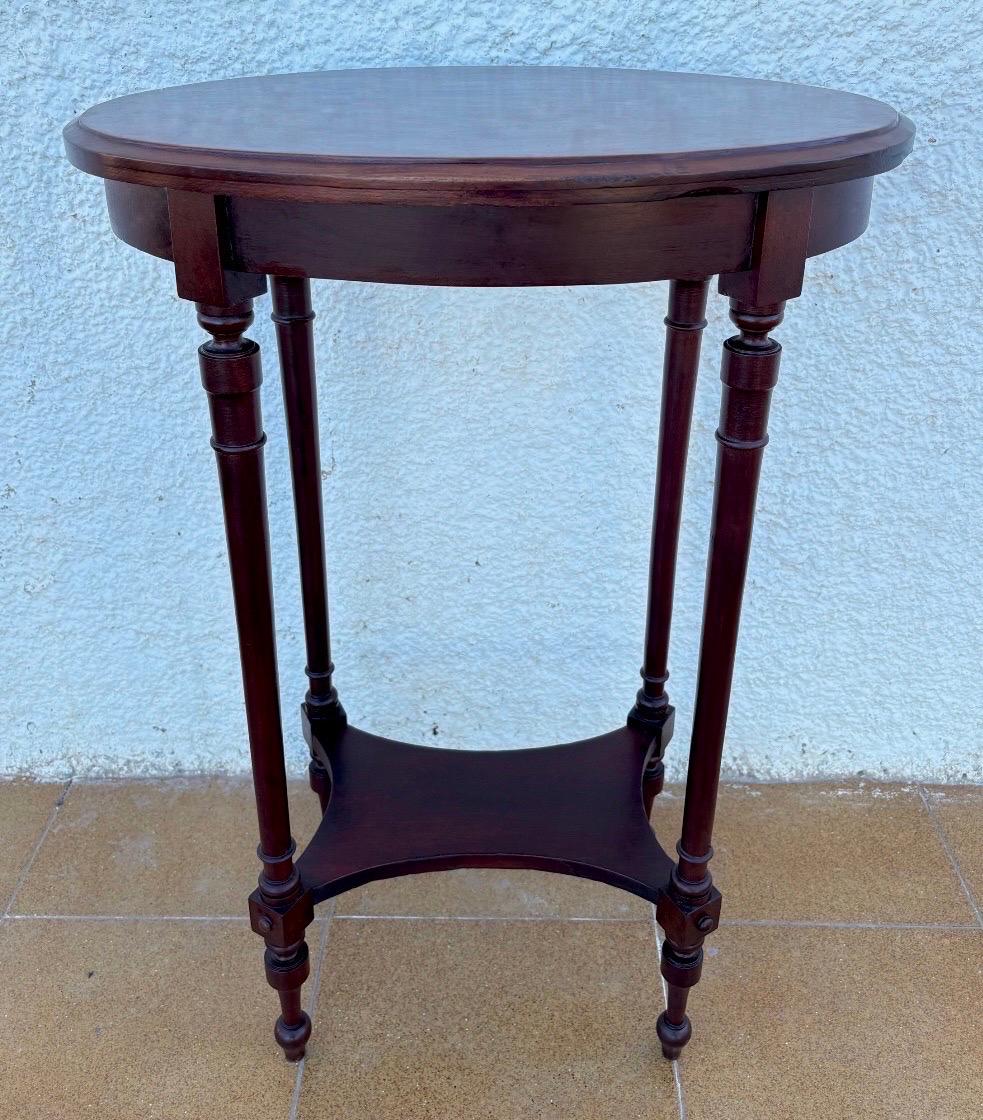 French mid-20th-century oak side table with an elegant oval top framed in wood, showcasing refined proportions and a timeless French Provincial character. The piece stands on four finely tapered stiletto legs with subtle turned details, connected by