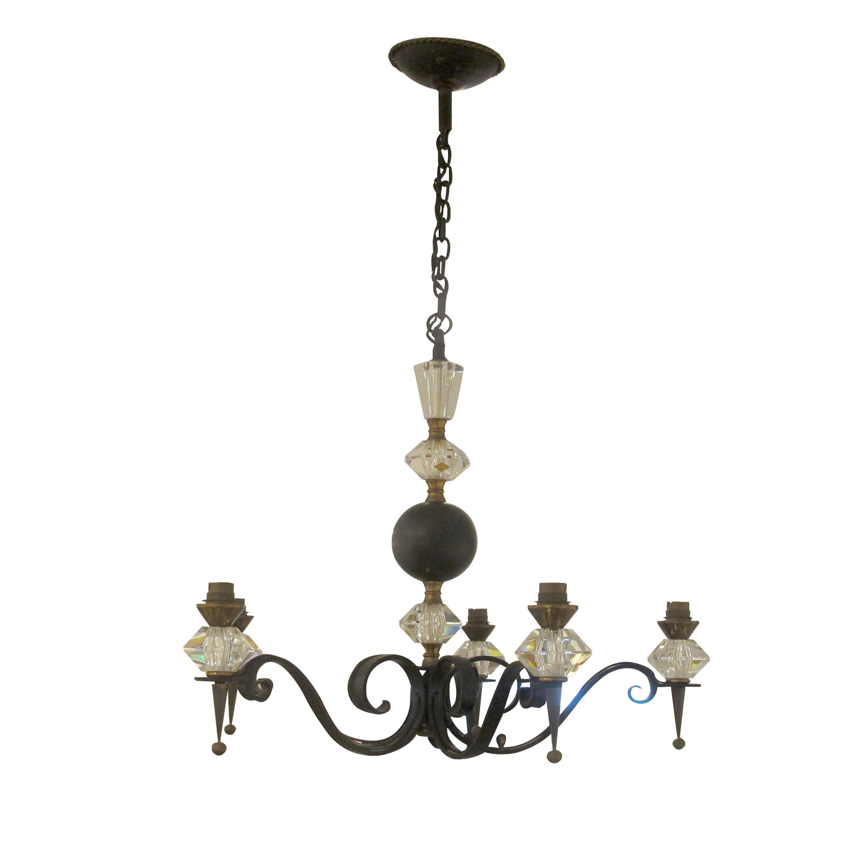 This is an elegant mid-20th-century chandelier featuring a harmonious blend of wrought iron, bronze accents, and fine Cristal de Sèvres glass elements. The chandelier is designed with five gracefully scrolling arms, each terminating in a