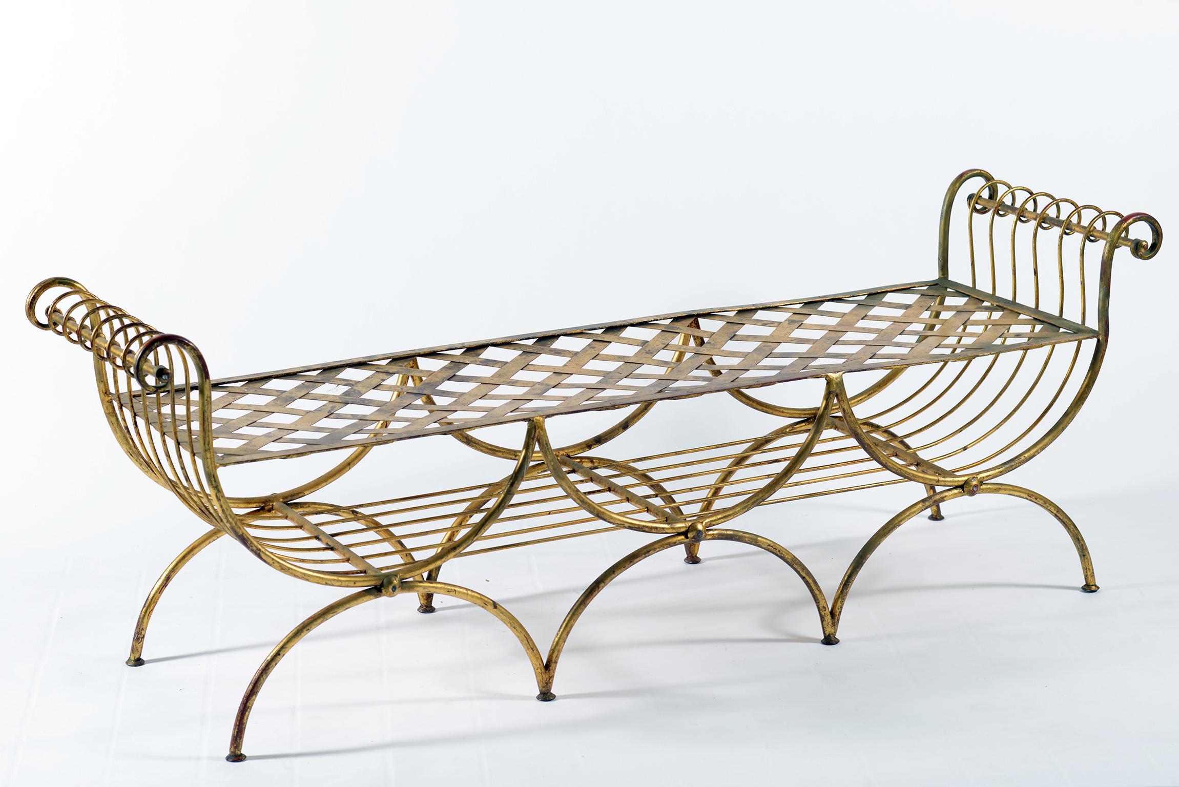 This handwrought iron bench has three legs supporting an arch on the front and back and two sort of curled arms with the seat woven with flat iron elements.
The bench can be used without a pillow or it is possible to make a fabric cushion.
The