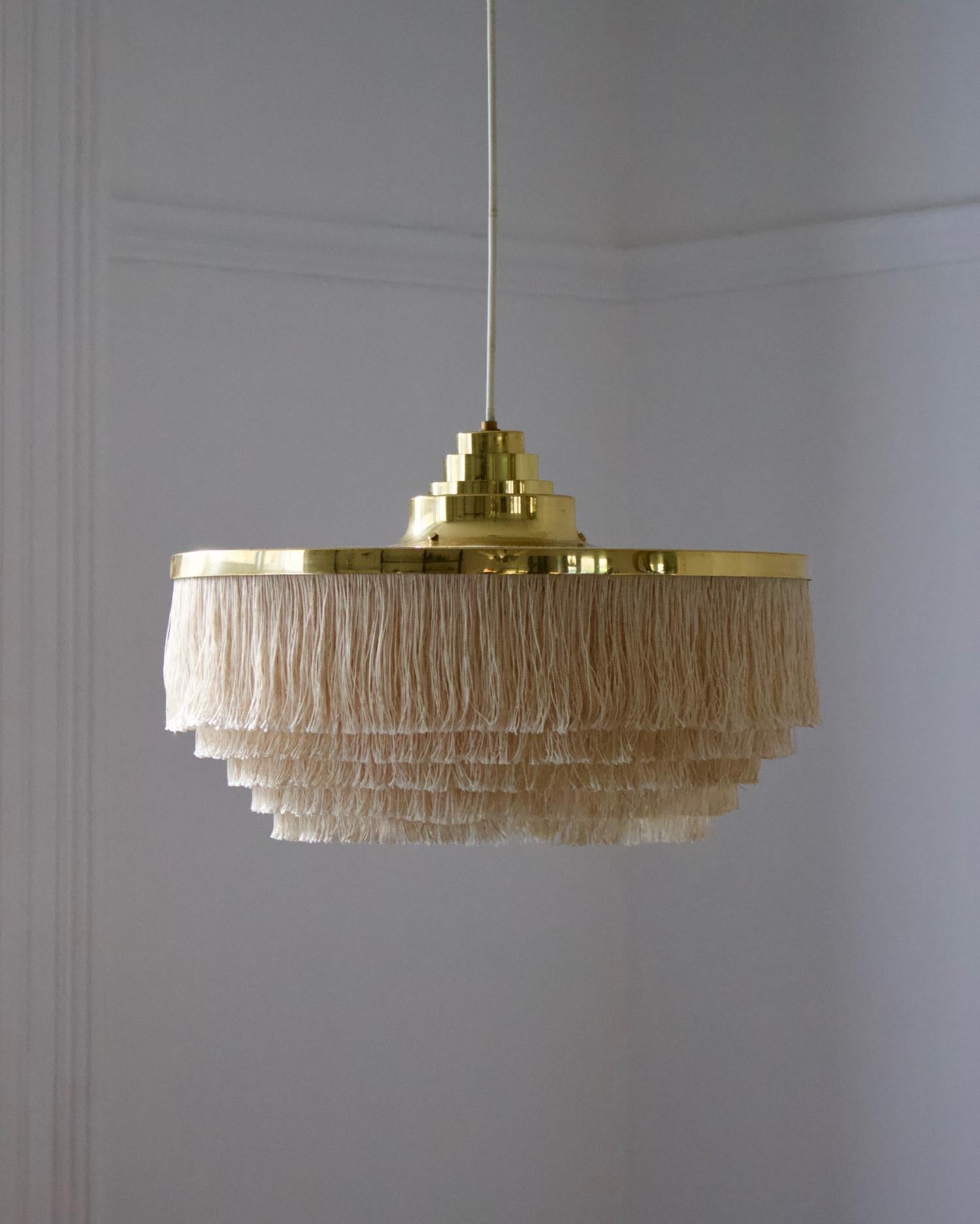 A fringed pendant light by the Swedish designer Hans-Agne Jakobsson for his own company in Markaryd, Sweden, mid-20th century. A very nice piece of Scandinavian modern design.

The fixture comprises a large brass shade with stepped detail, and