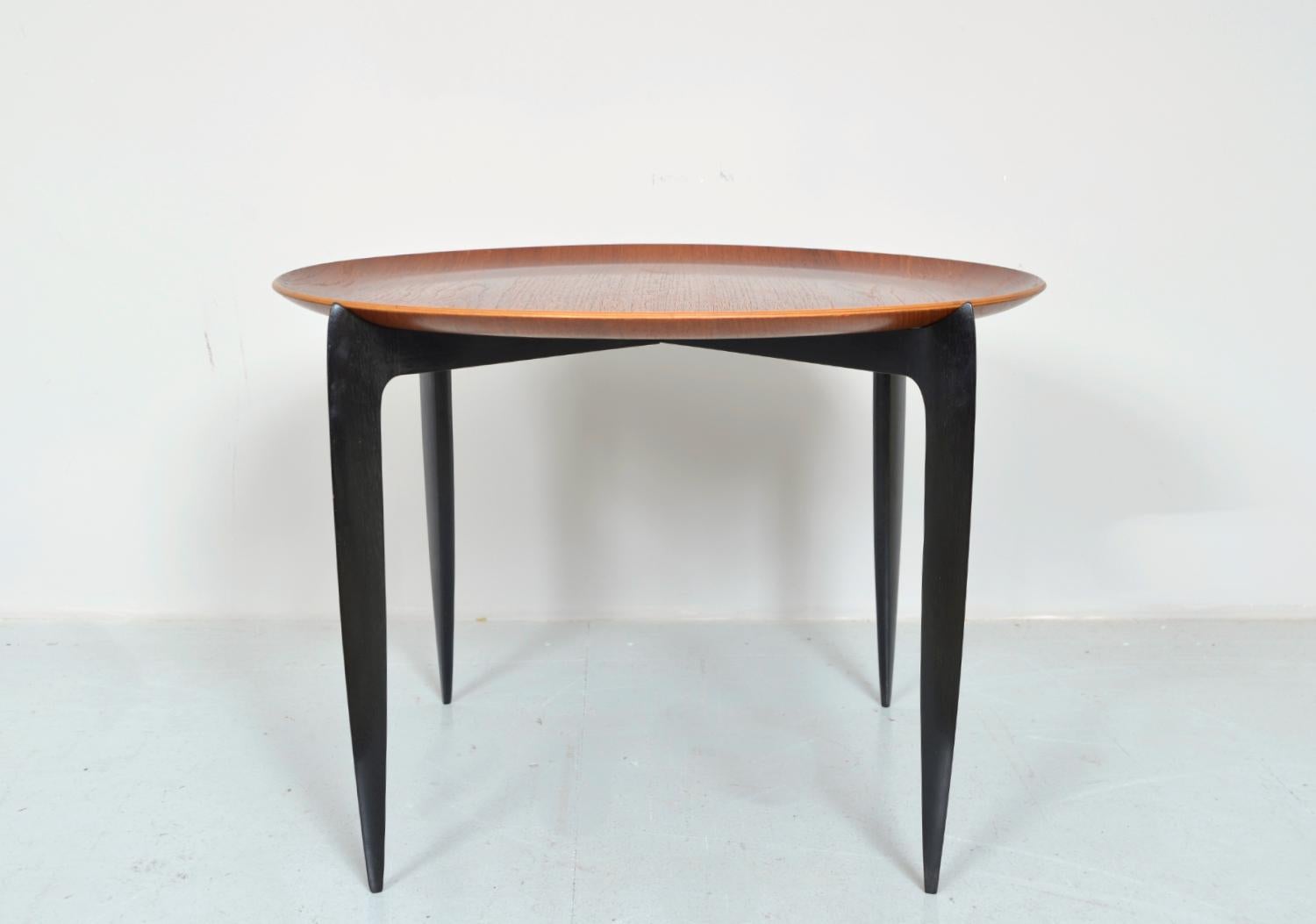 A very stylish teak tray table, model 4508, designed by H. Engholm and Sven Aage Willumsen for Fritz Hansen in 1957. The circular table top tray is beautifully sculpted in teak and simply sits on top of a folding wood base of four sabre legs in