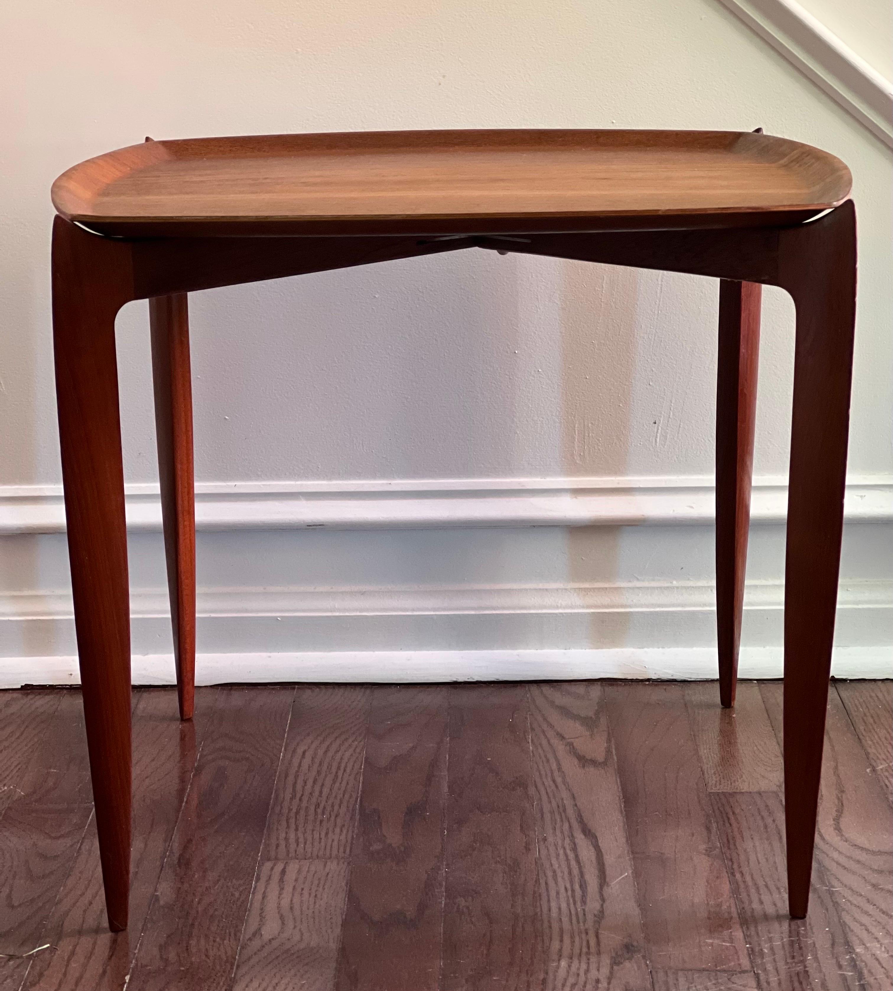 Wonderful mid-century teak tray table by Fritz Hansen, 1960's. The rounded square table is removable and sits on a folding base. The tabletop edges are curved slightly upward creating lovely contour and providing support. True to Scandinavian