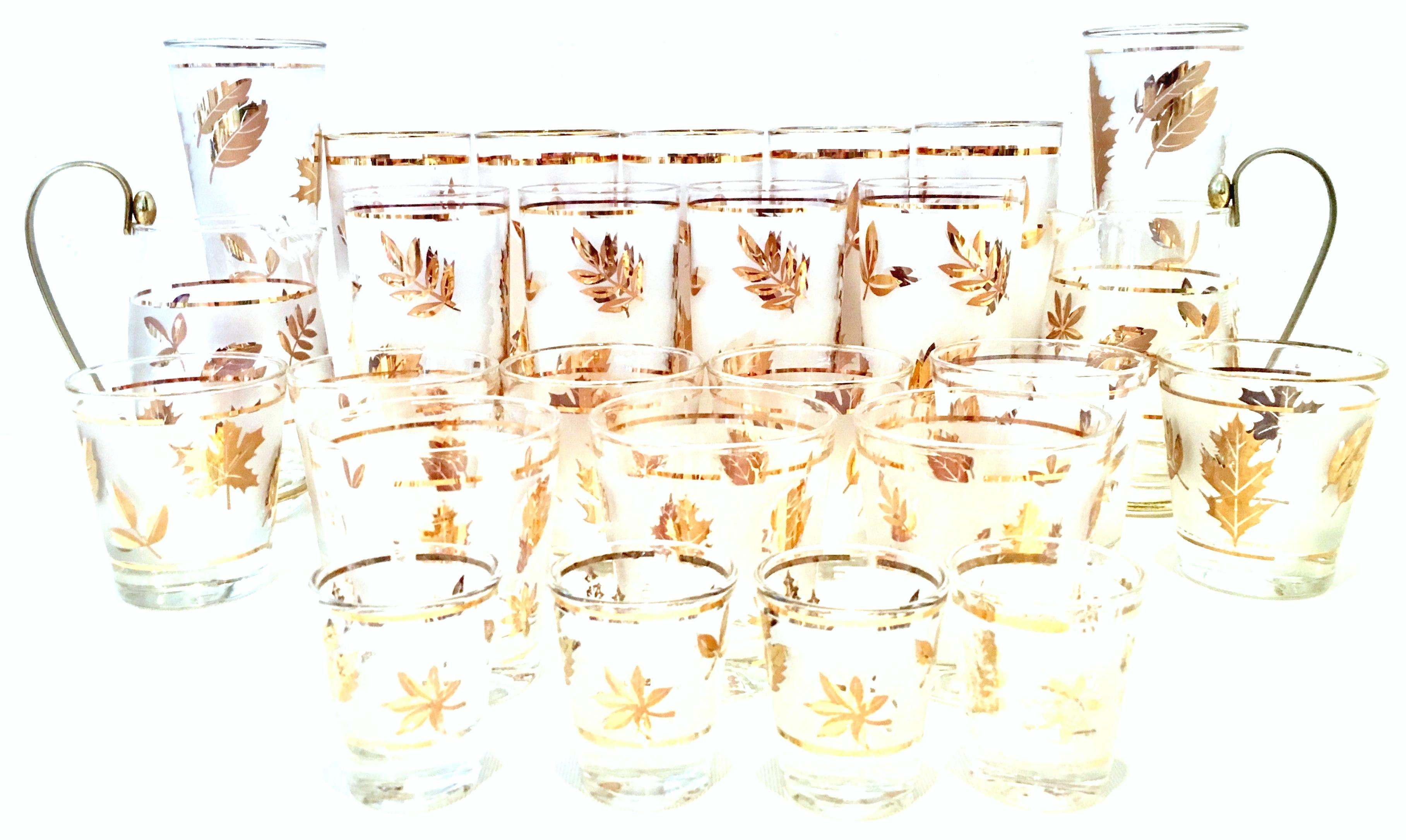 Mid-Century Modern frosted & 22-karat gold leaf motif drinks set of 26 pieces. Set includes, nine cocktail glasses, five Tom Collins glasses, four high ball glasses, four shot glasses, two pilsner glasses and two brass handle