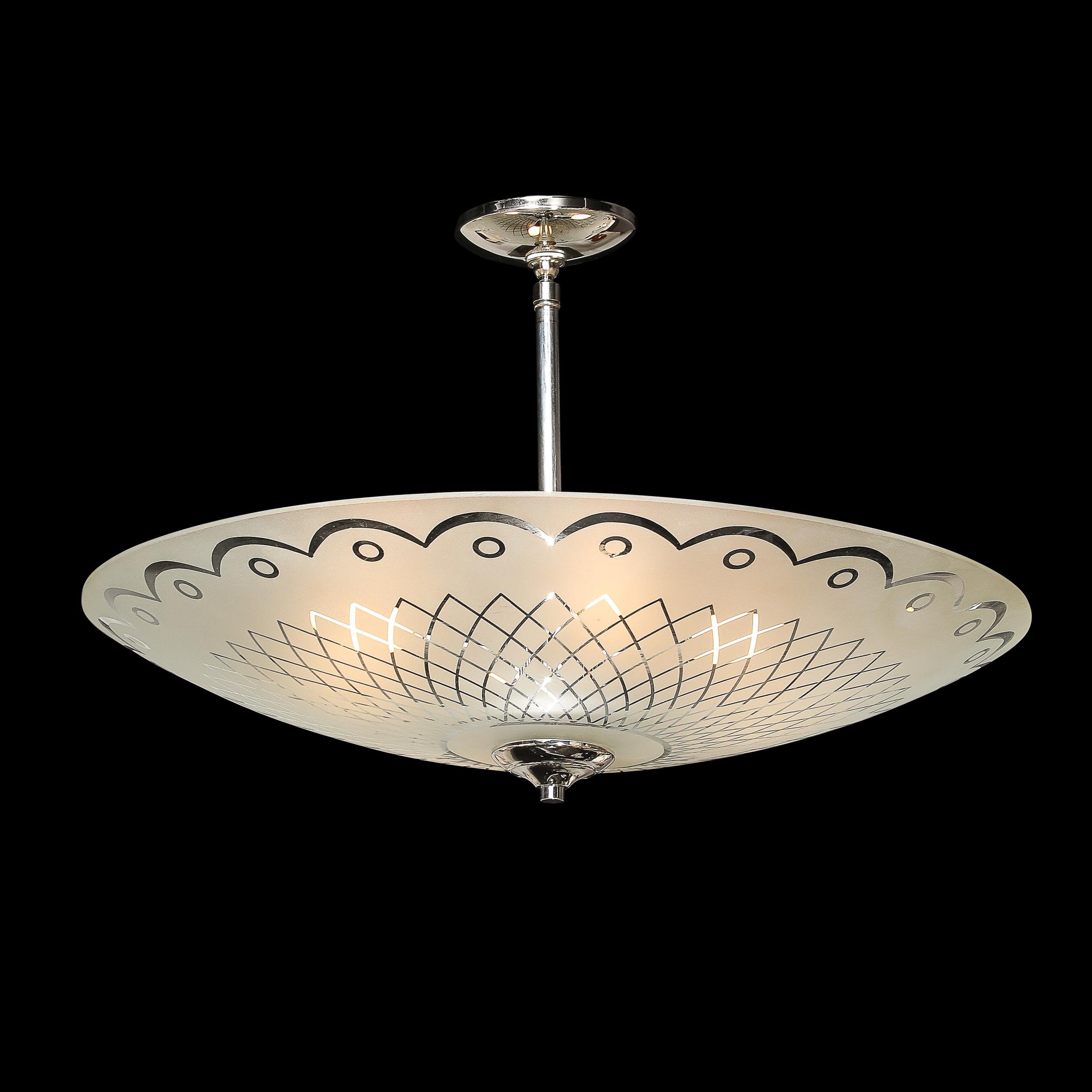 This captivating Mid-Century Modernist pendant chandelier, crafted in Italy circa 1950, features a frosted glass shade adorned with highly elegant and bold geometric motifs. The sleek symmetry of the design is complemented by polished chrome
