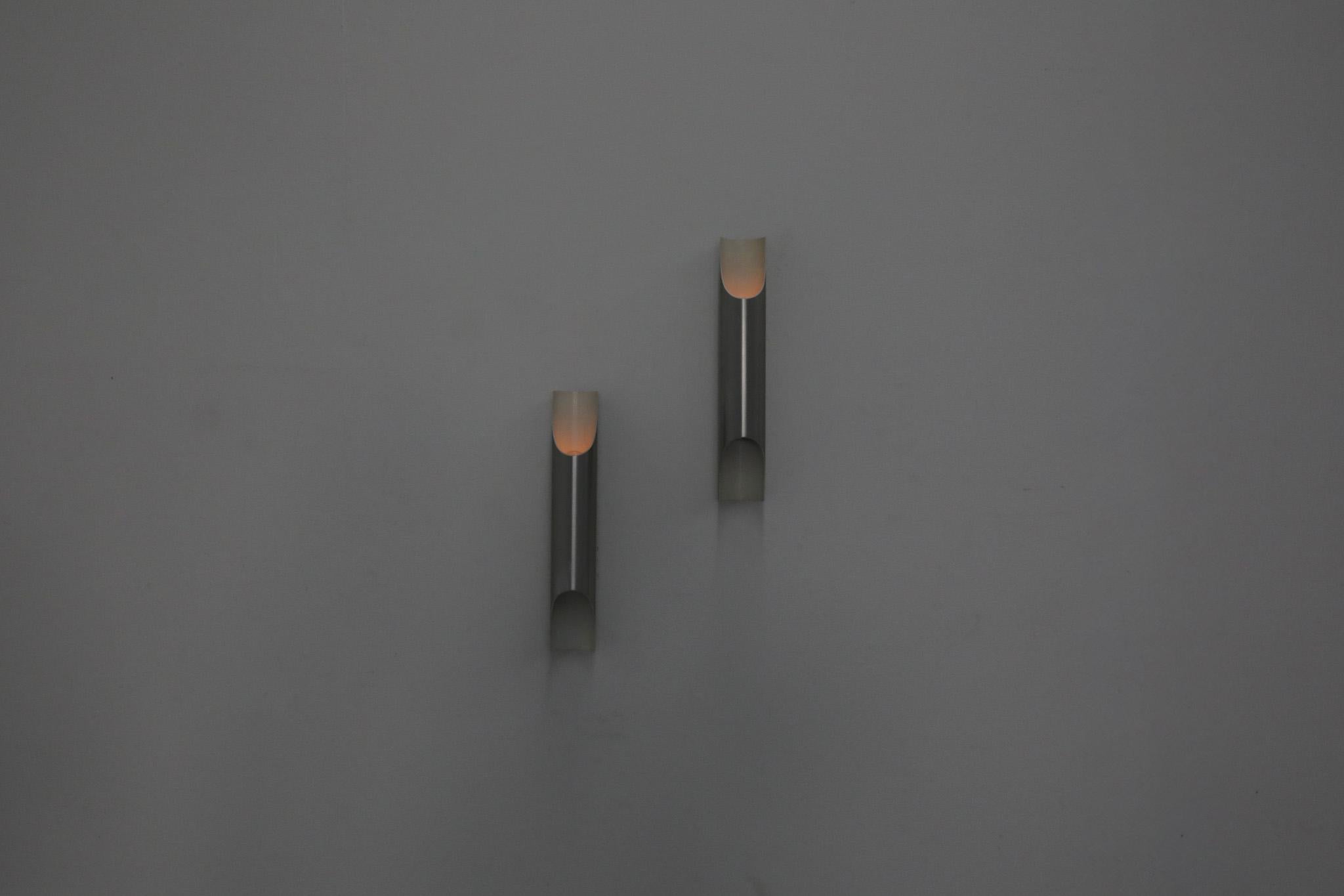 Mid-Century wall lamps with aluminum tube shades on black enameled bases. Designed by Finnish architect Maija Liisa Komulainen for RAAK, Holland. This is an Iconic dutch design from the 1970s. In original condition with some scratching and enamel