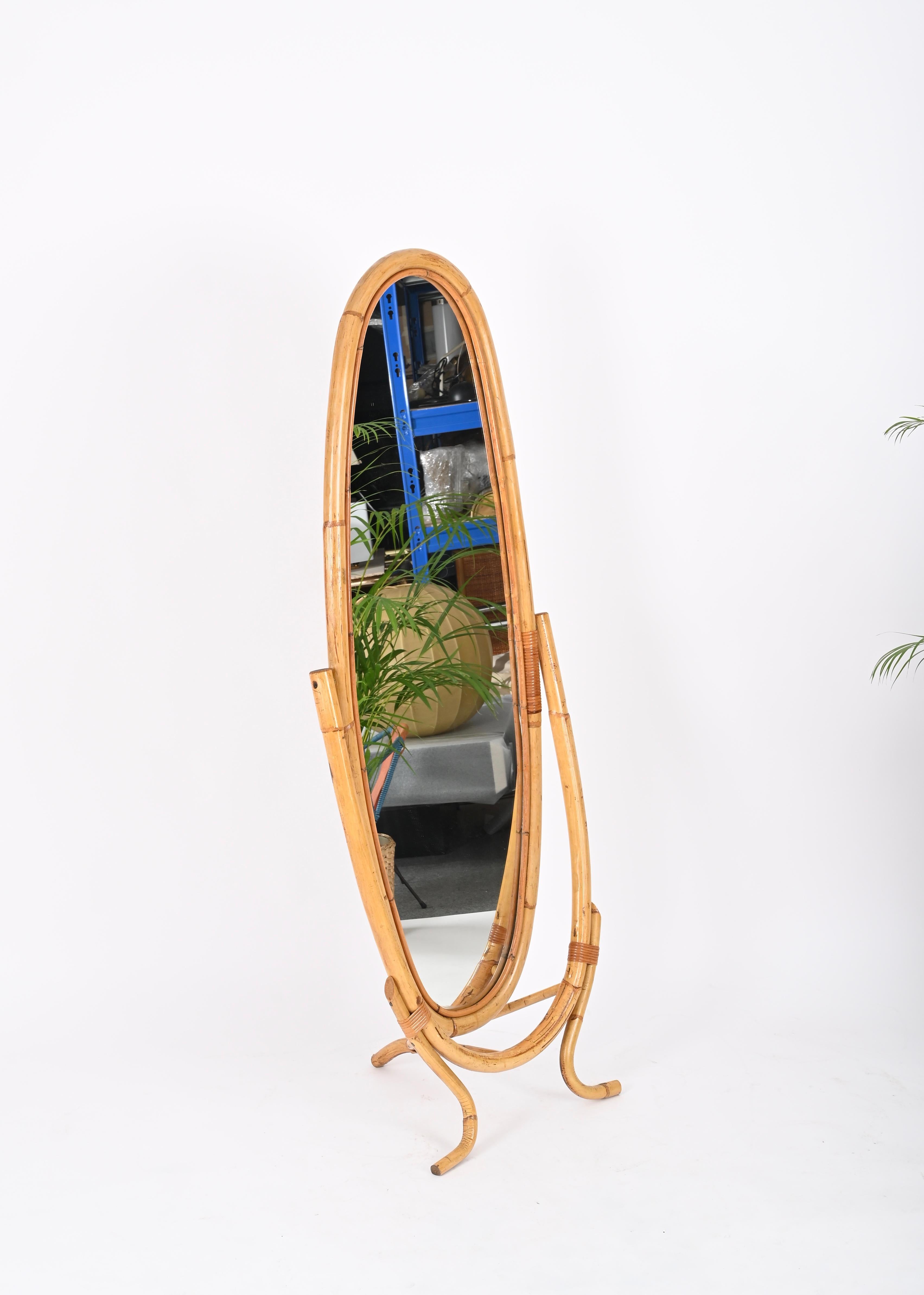 Fantastic mid-century French Riviera style floor mirror in curved bamboo, rattan and wicker. This unique mirror was produced in Italy during the 1960s.  

This gorgeous item has oblong shaped mirror mounted in a curved bamboo frame that is enriched