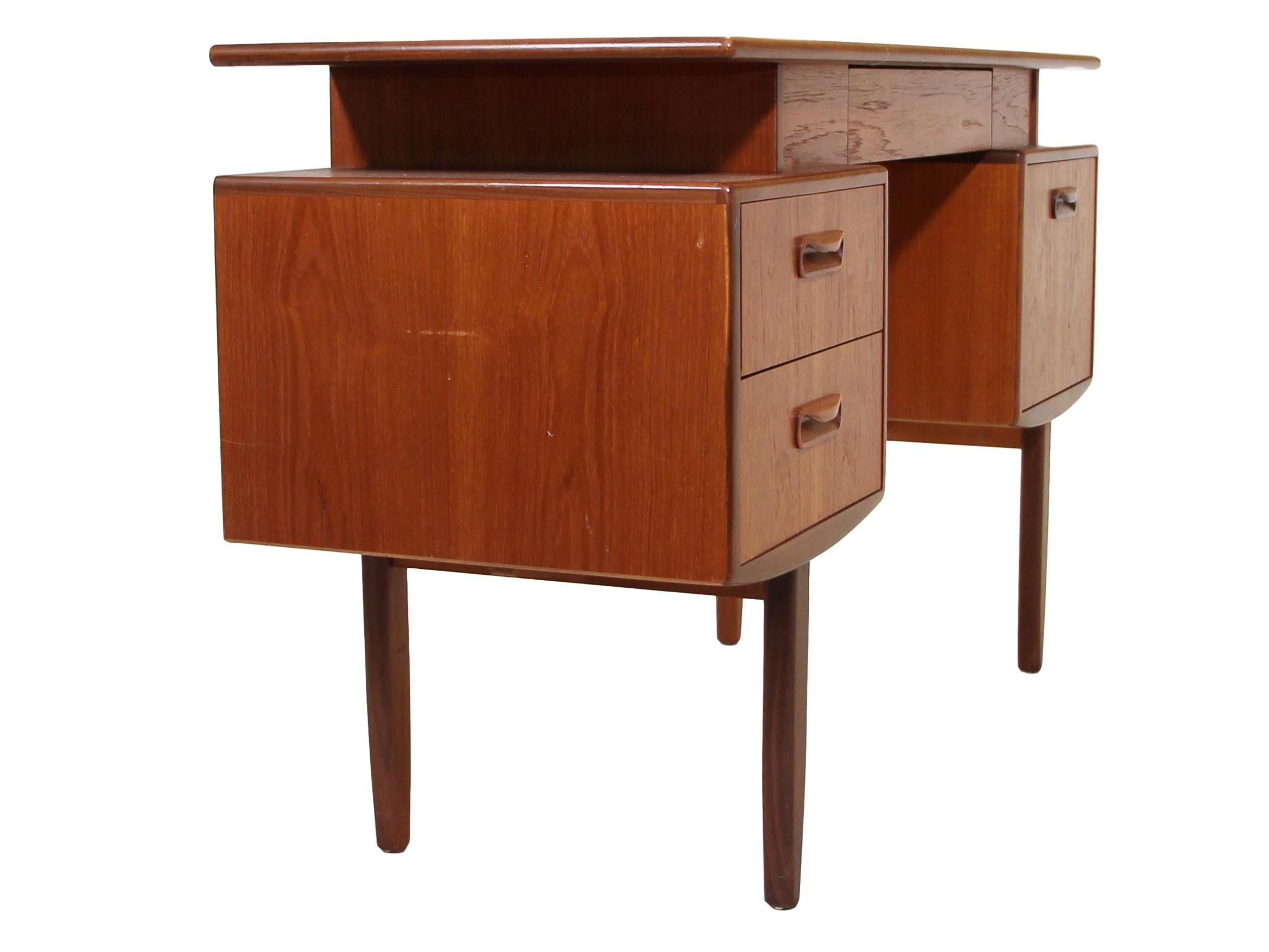 Midcentury teak vanity / desk. Danish modern in style. It features floating top design, 2 drawers on the left and a door and cabinet on the right. Secret drawer has original black fabric. Gorgeous continuous grain pattern on the front of the