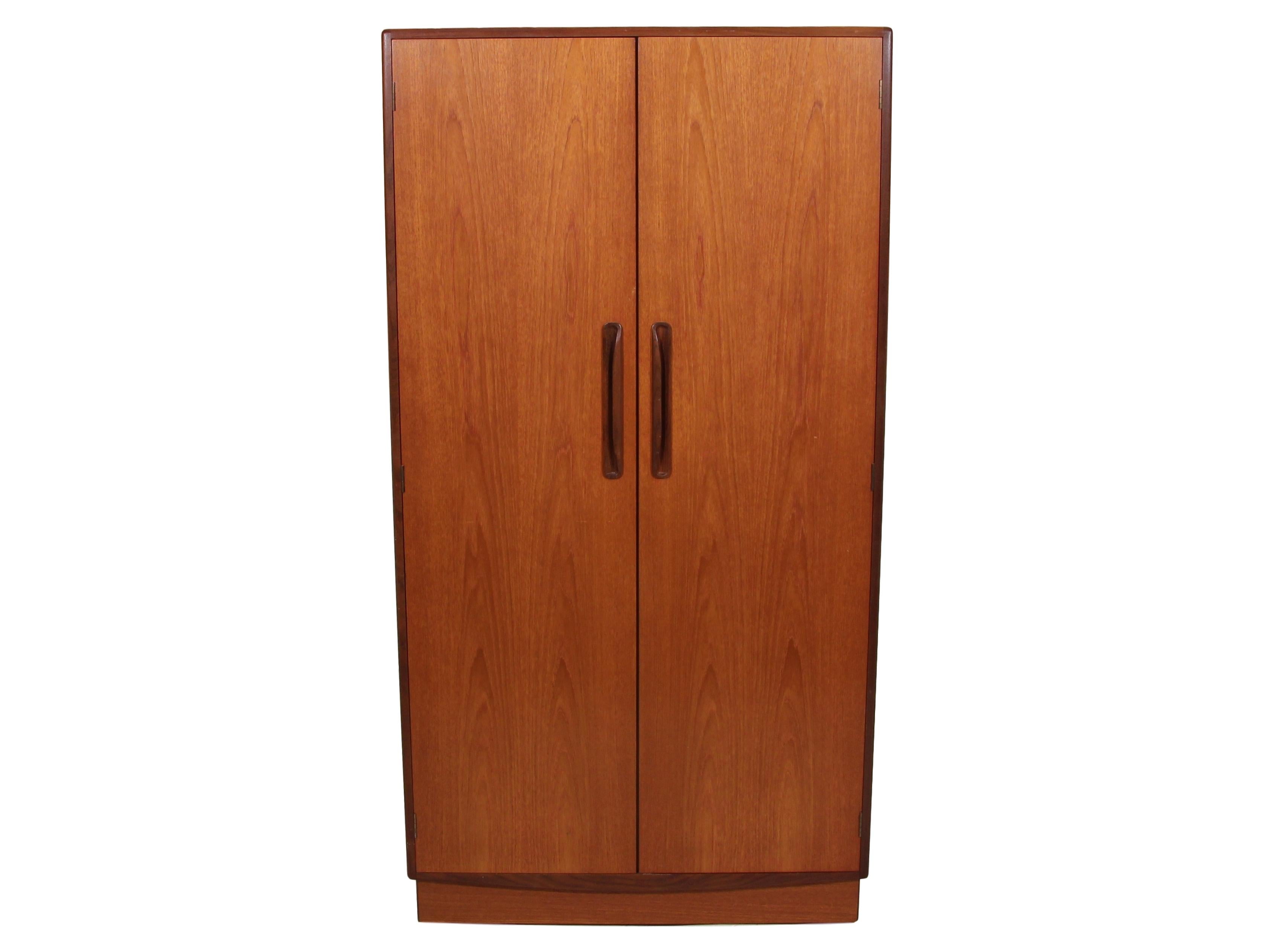 Teak wardrobe by G Plan. Designed in the 1960s by Victor Bramwell Wilkins for G Plan's Fresco Range. Danish modern in style.
Two-door wardrobe with half hanging space on the left side and shelves and drawer space on the right. Stunning grain