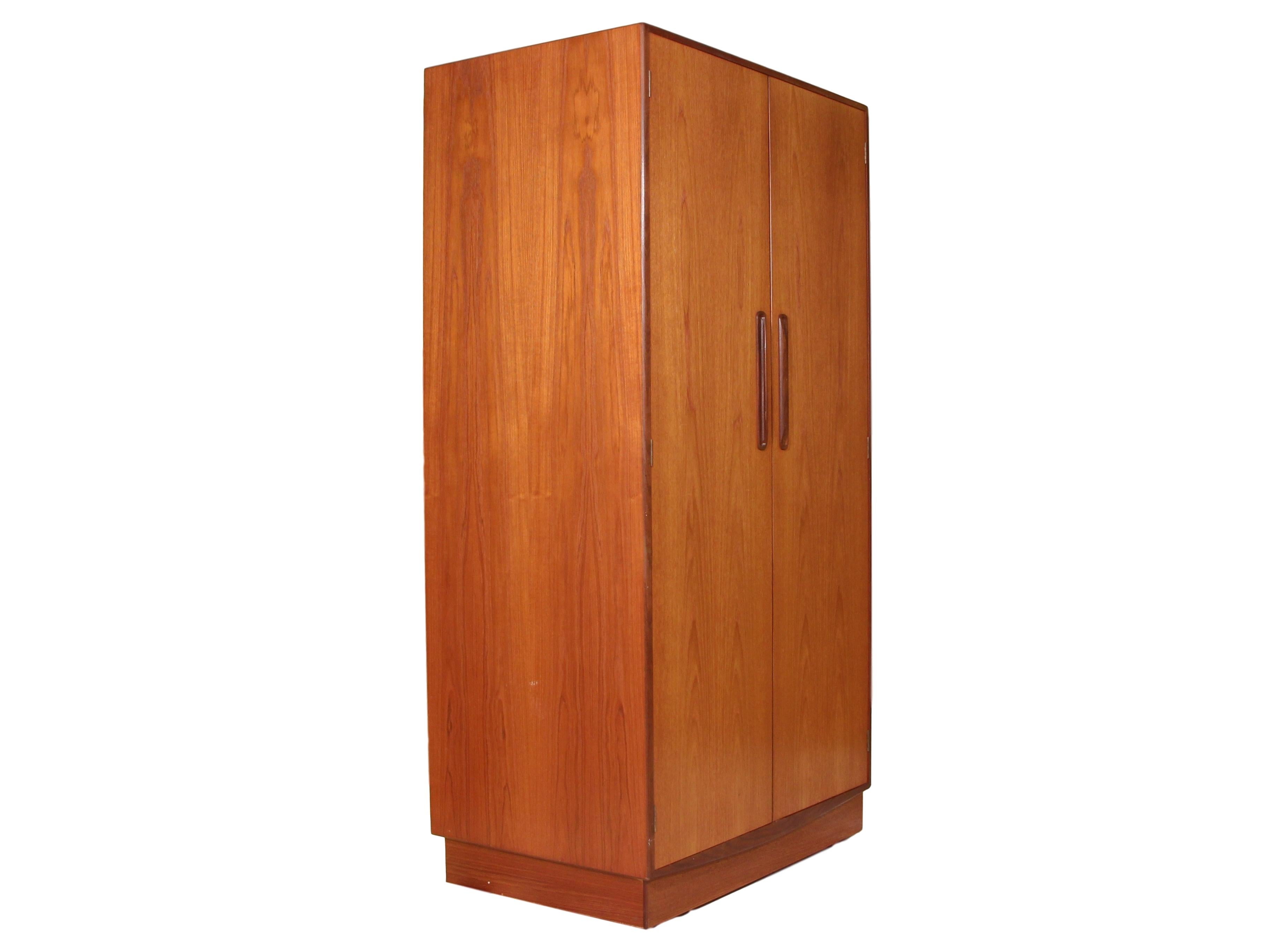 Amazing teak wardrobe by G Plan. Designed in the 1960s by Victor Bramwell Wilkins for G Plan's Fresco Range. Danish Modern in style. Two-door wardrobe with half hanging space on the left side and shelves and drawer space on the right. Stunning grain
