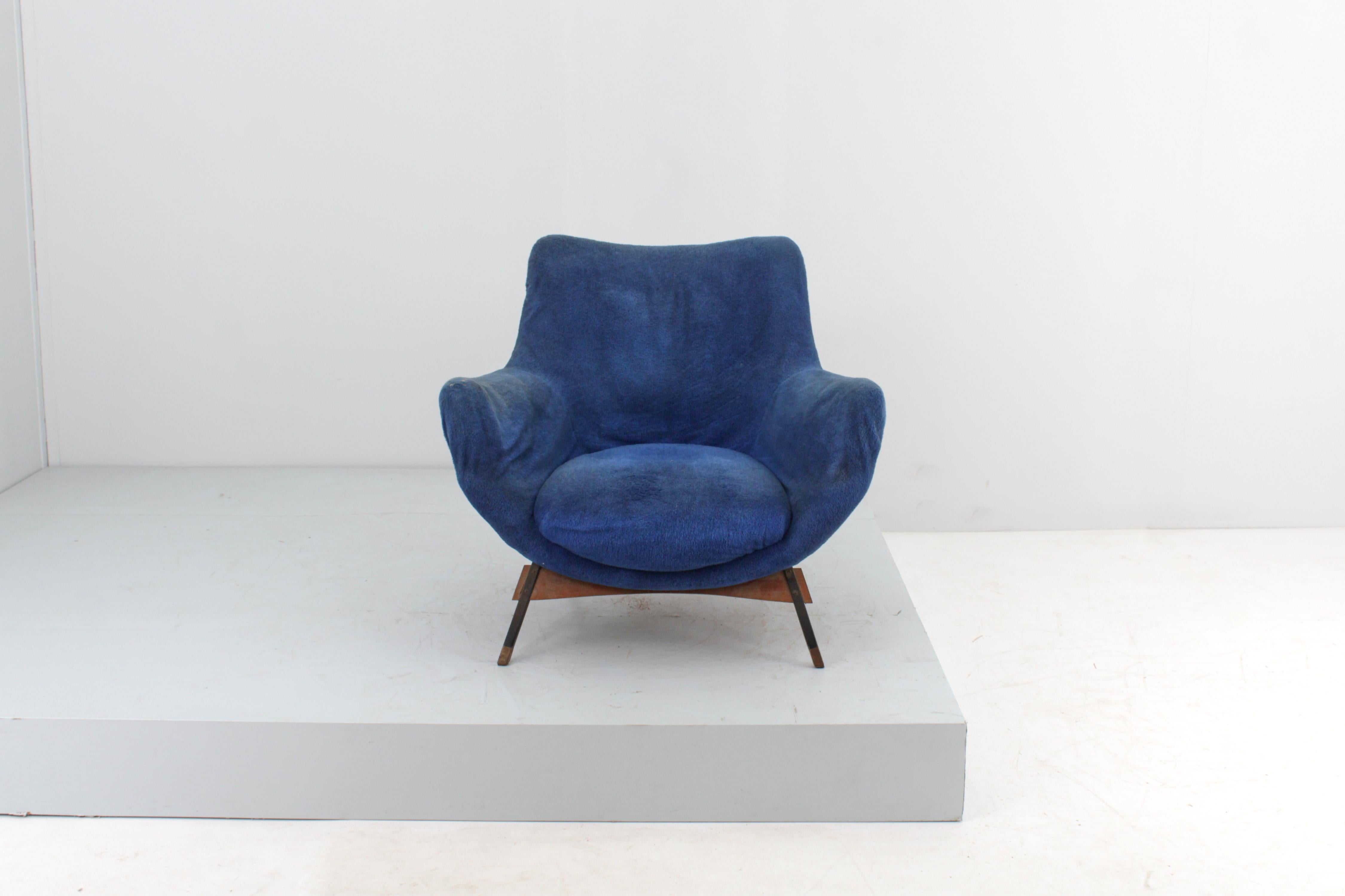 Armchair with a very elegant curved design with metal and wood structure with padding lined in blue velvet, with inclined geometric feet, in wood and brass. Italian production attributable to Guglielmo Veronesi for ISA Bergamo, in the style of the