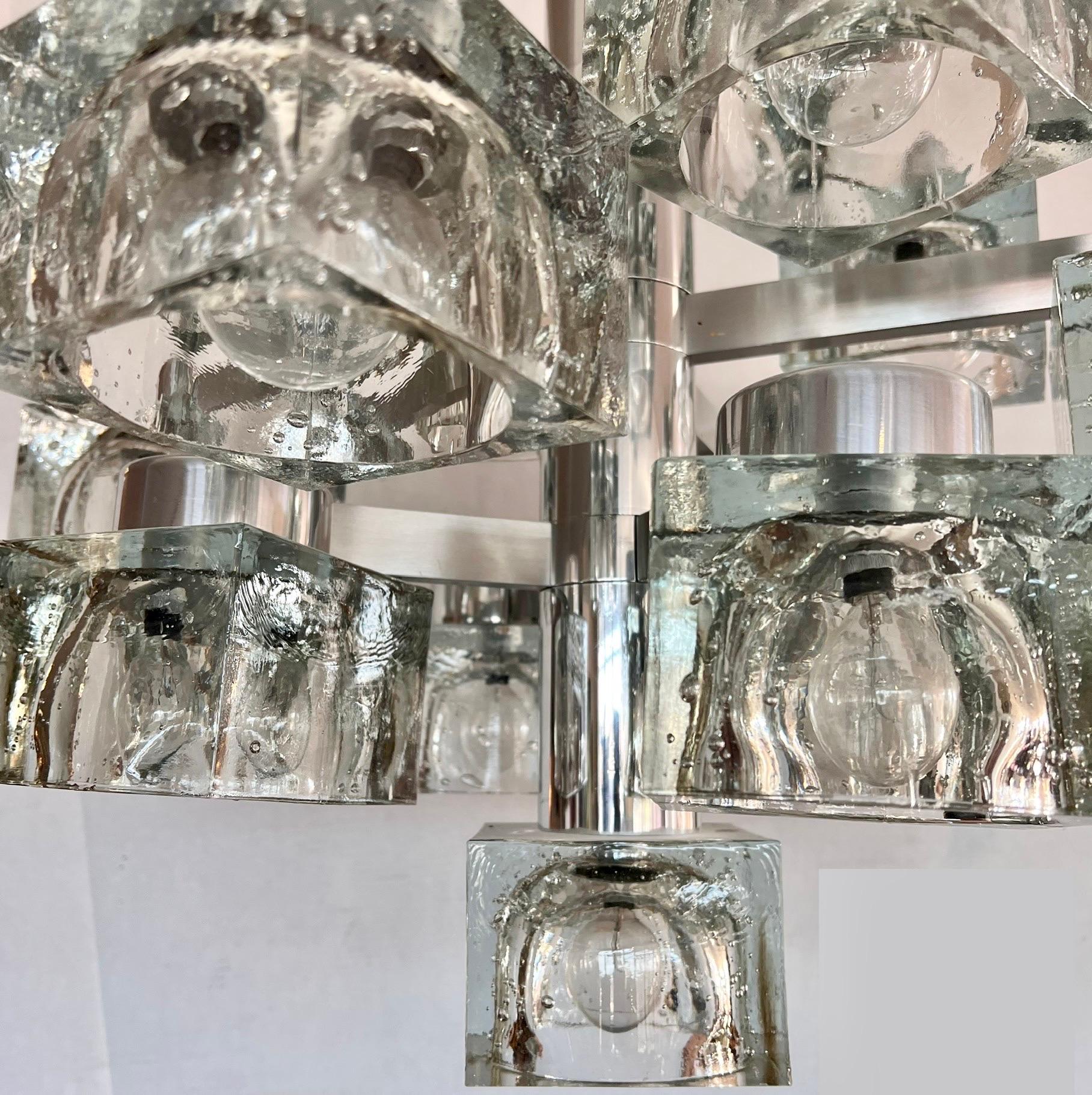 A Lightolier chandelier by Italian designer Gaetano Sciolari. It features nine glass shades resembling ice cubes with chrome body. It is in excellent vintage condition, circa 1970s.
32
