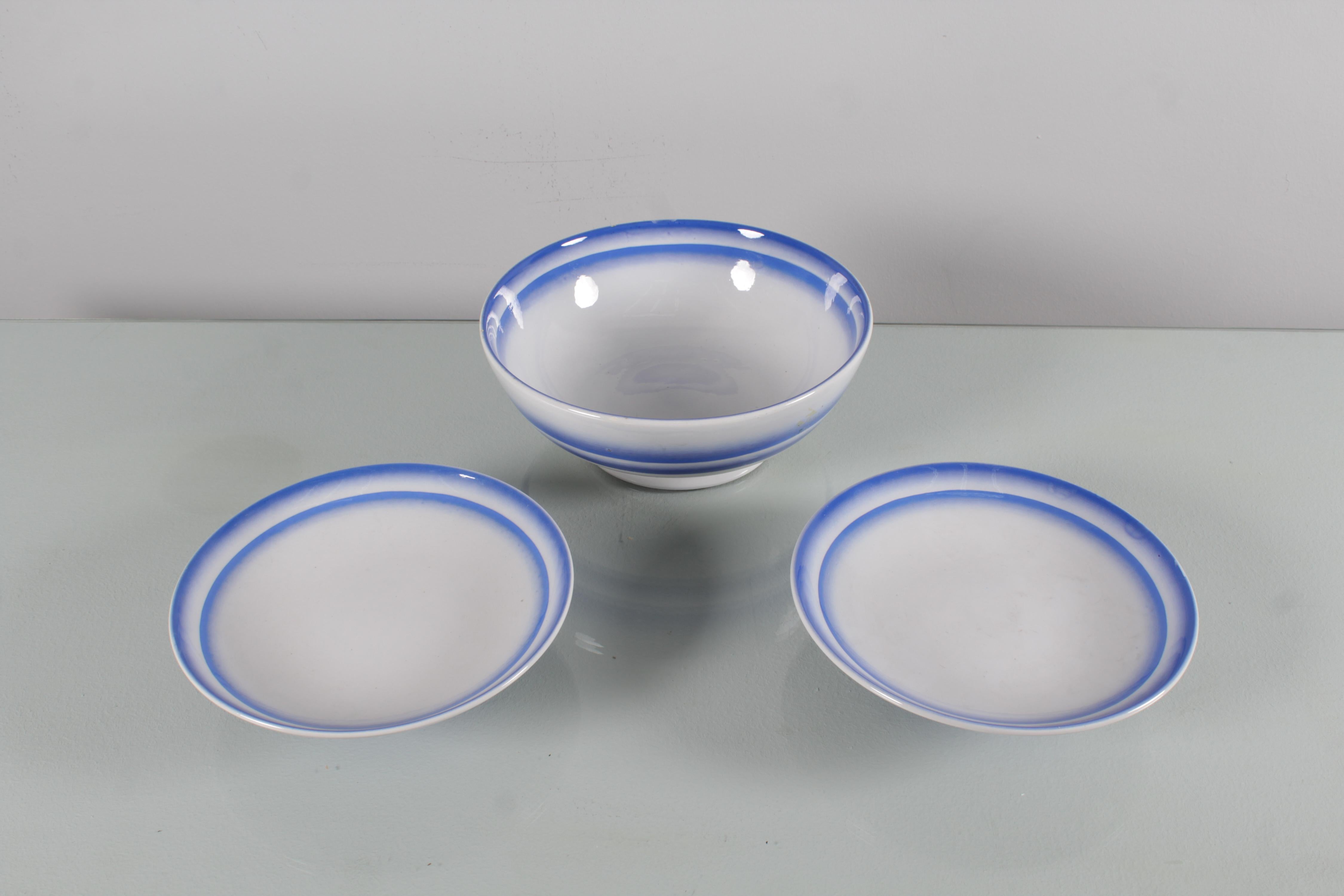 Elegant service de table en céramique blanche peinte à l'aérographe avec des motifs circulaires bleus. Un saladier et deux plateaux de service, avec support central. Fabrication italienne 