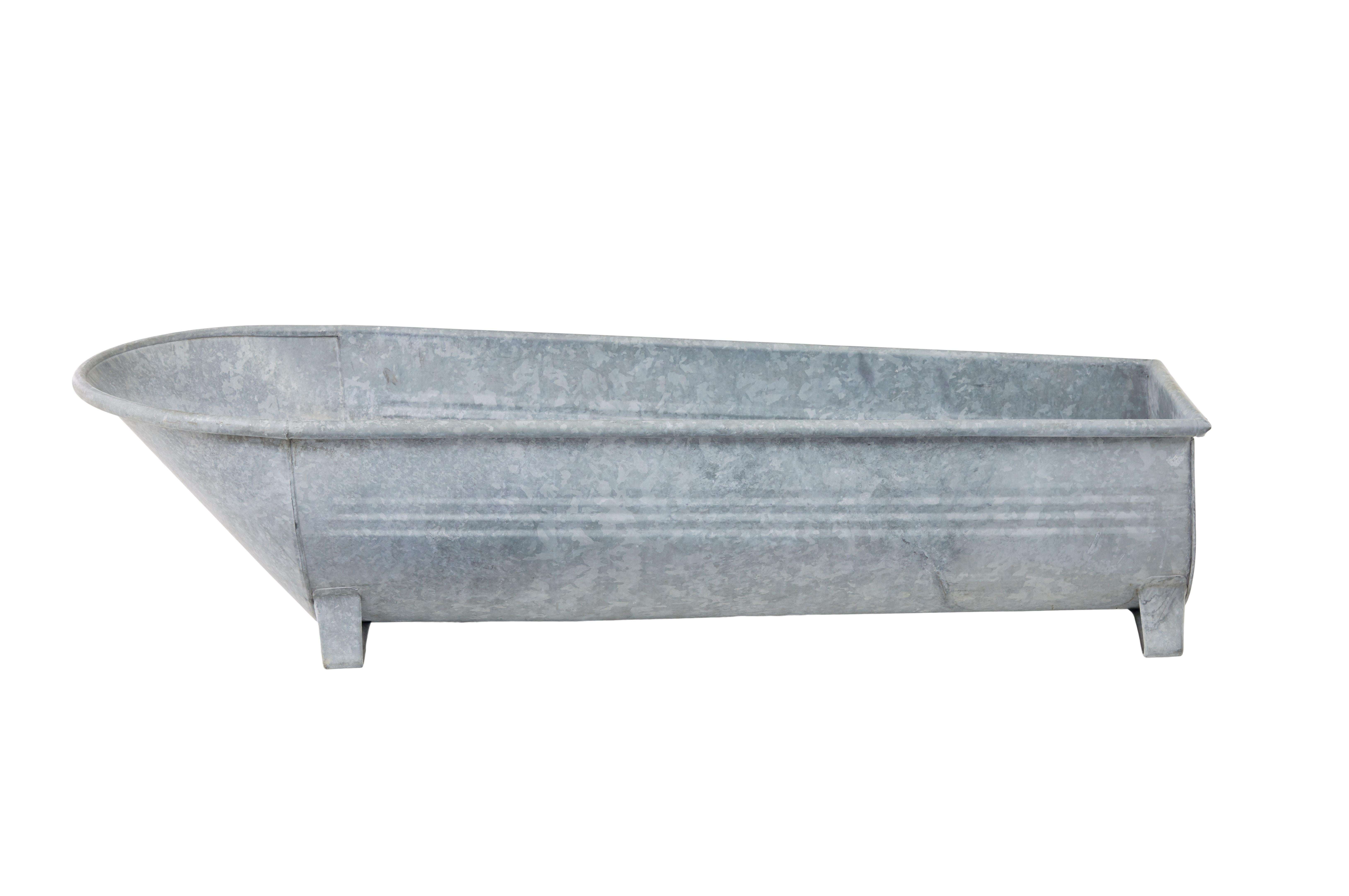Mid century galvanised tin bath circa 1940.

Good quality Scandinavian tin bath which would also function well as a garden planter or installation.  Made from galvanised tin to prevent rusting, coffin shaped with a roll top lip, standing on shaped