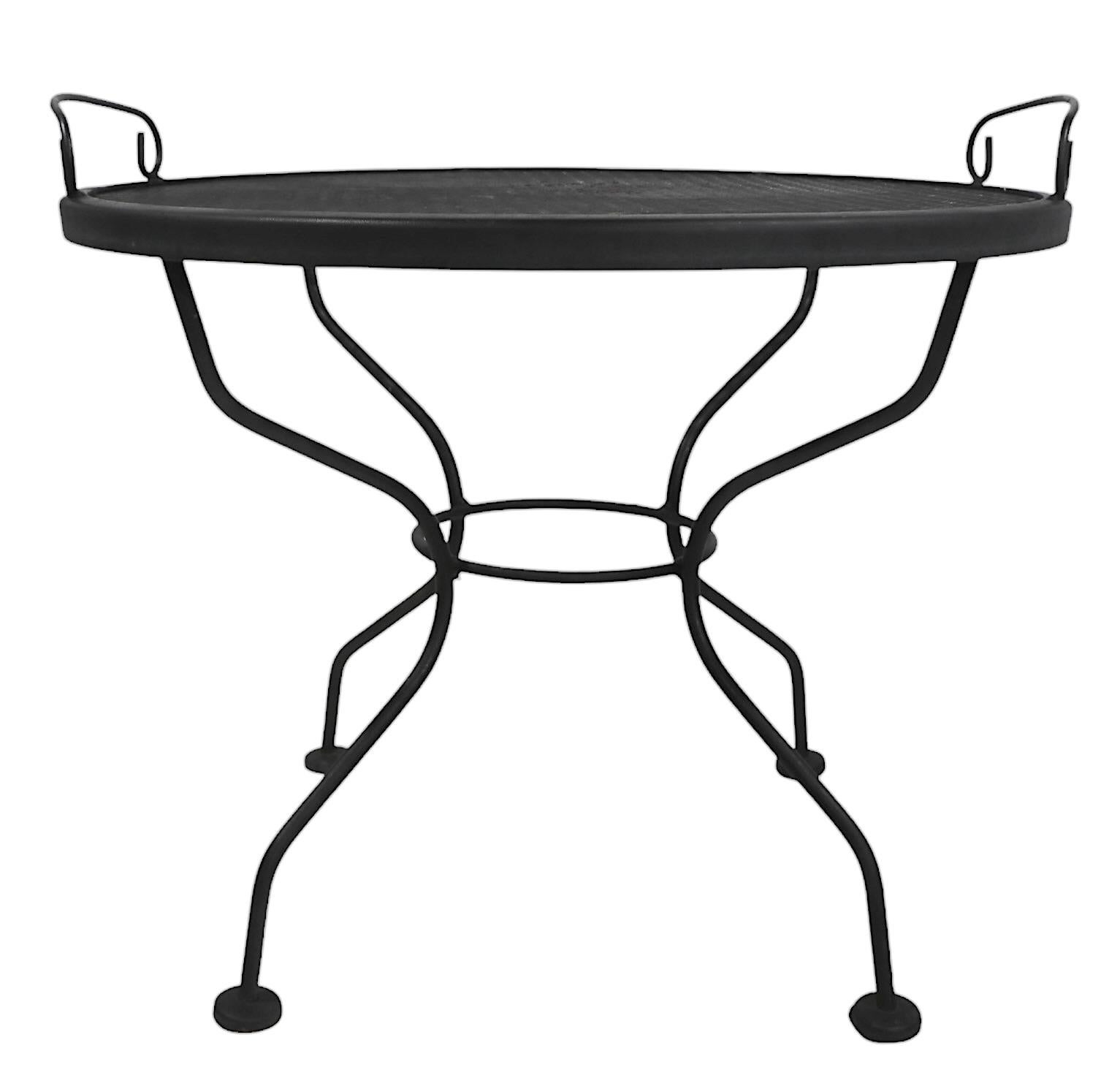 Unusual vintage tray top wrought iron and metal mesh garden, patio, poolside table, attributed to the Woodard Furniture Company circa 1950/70’s.
The table features a wrought iron base, with a removable metal mesh tray top. Perfect for outdoor